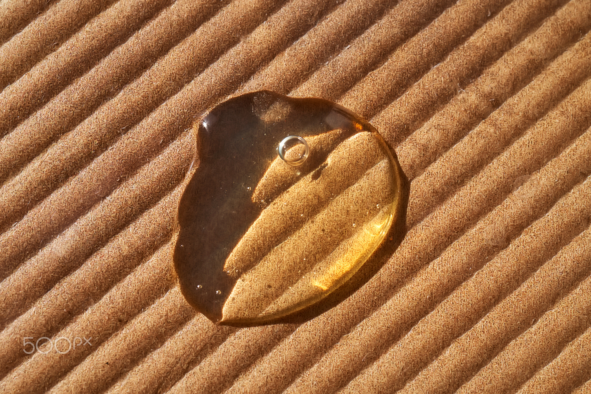 A drop of cosmetic oil on a corrugated surface.