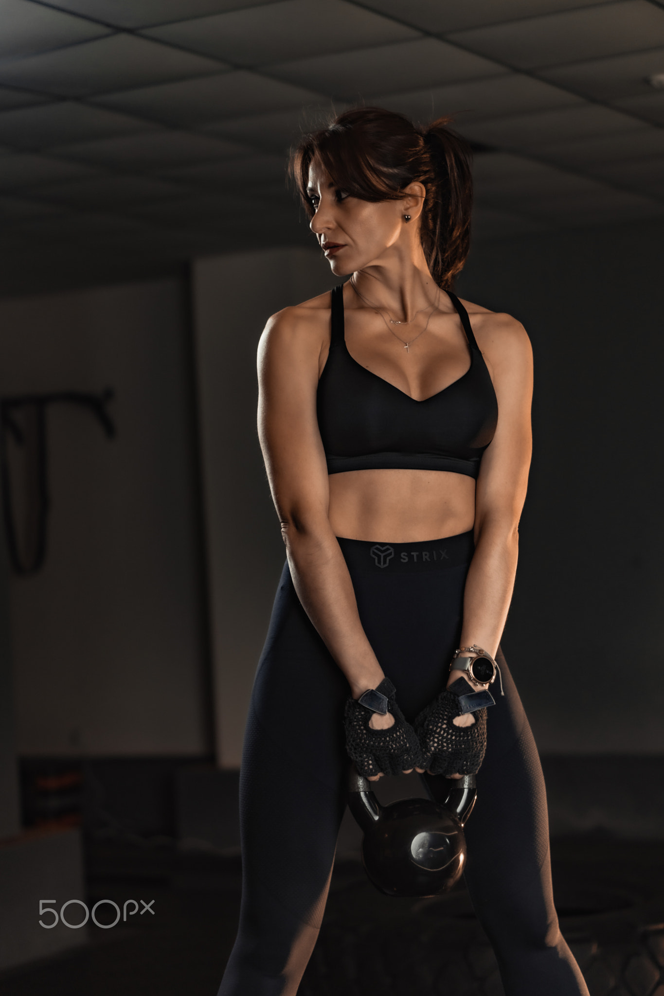 A passionate fitness enthusiast is diligently training with various kettlebells at a stateoftheart