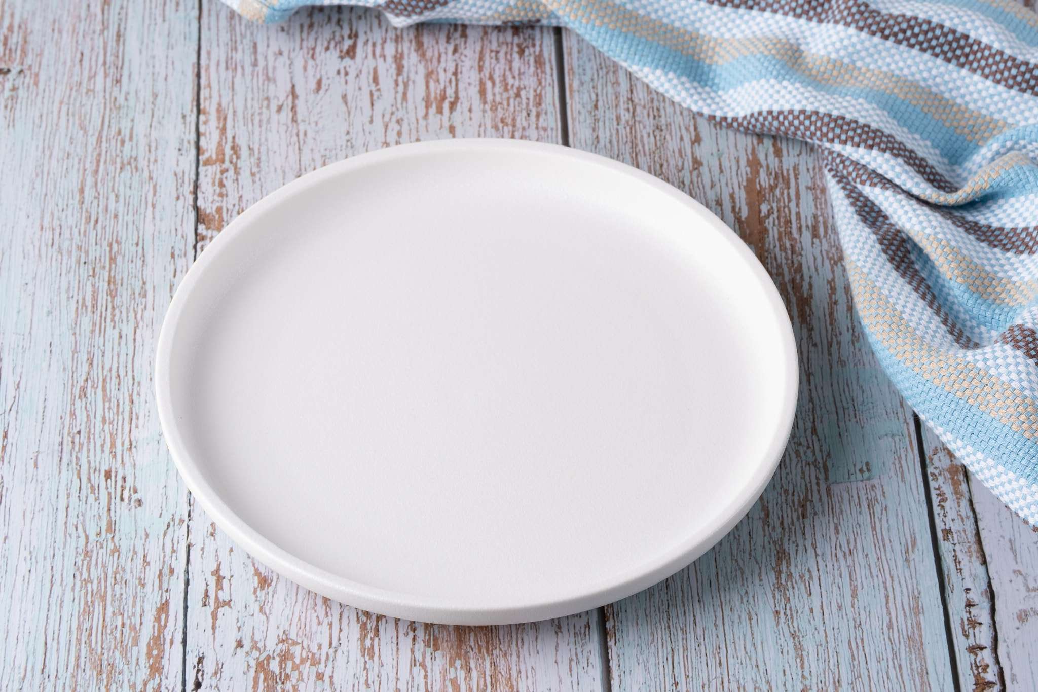 Empty plate on blue wooden background