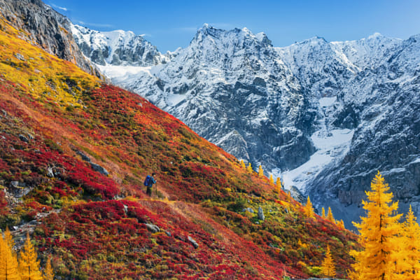 Lush fall foliage colors of alpine meadows against mountains covered with fresh snow.  by Marina Poushkina on 500px.com