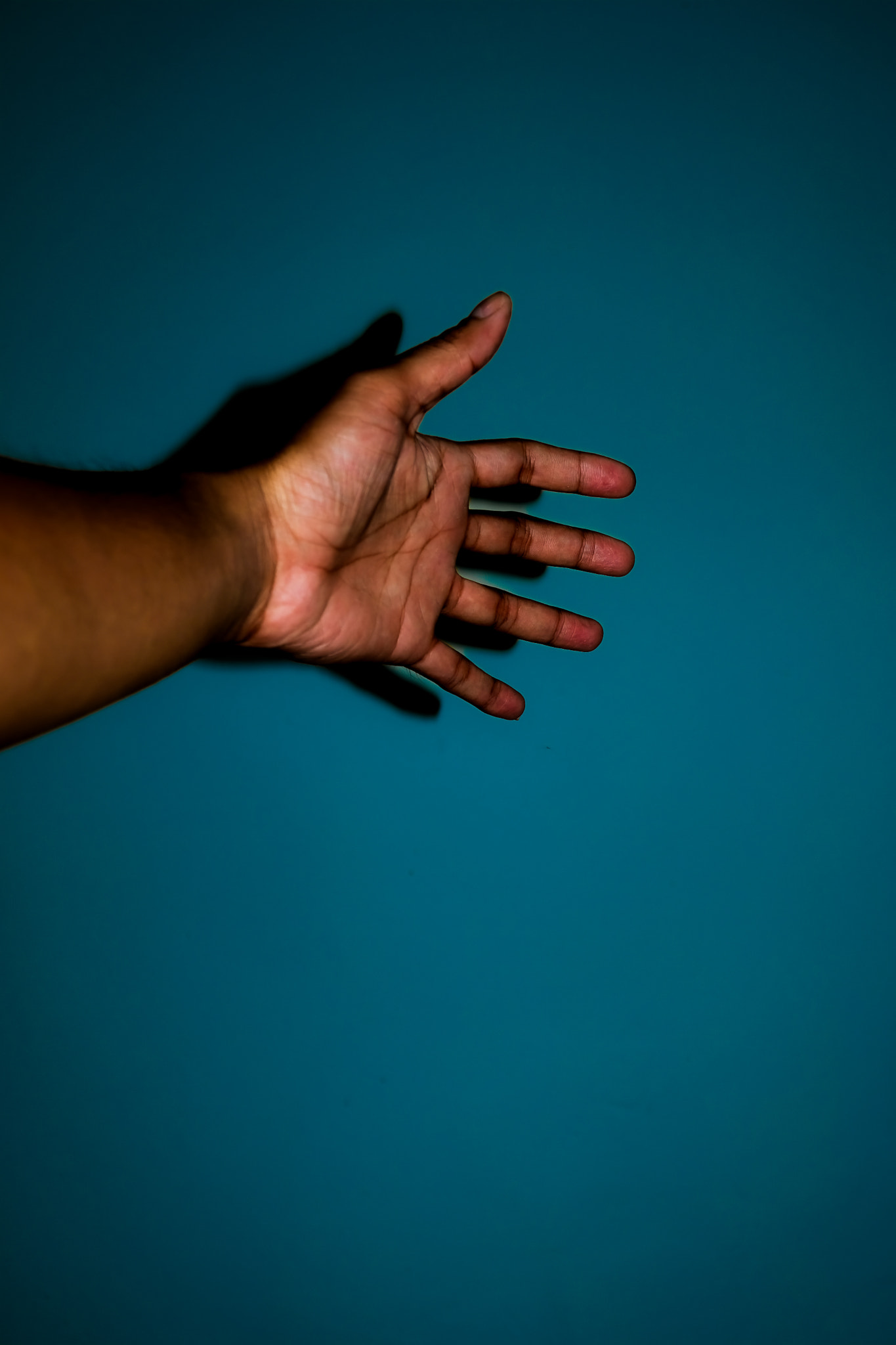 Cropped hand of man against blue background