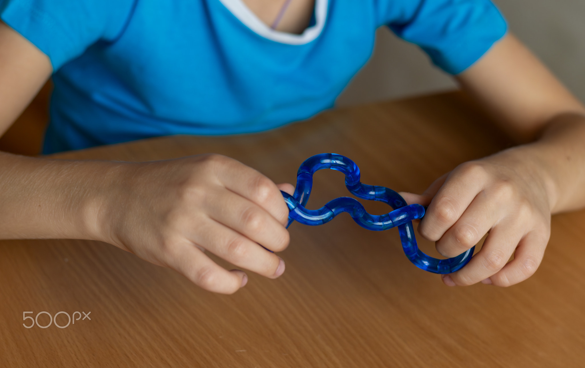 Logic toy antistress snake in hands of child. Close-up. Mental health, stress relief, development of