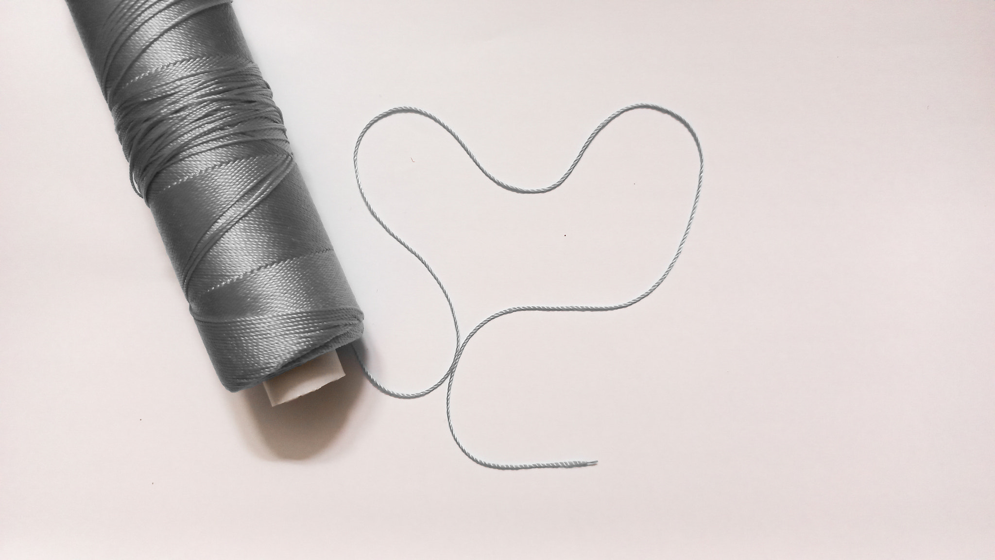 Close-up of thread spool over white background