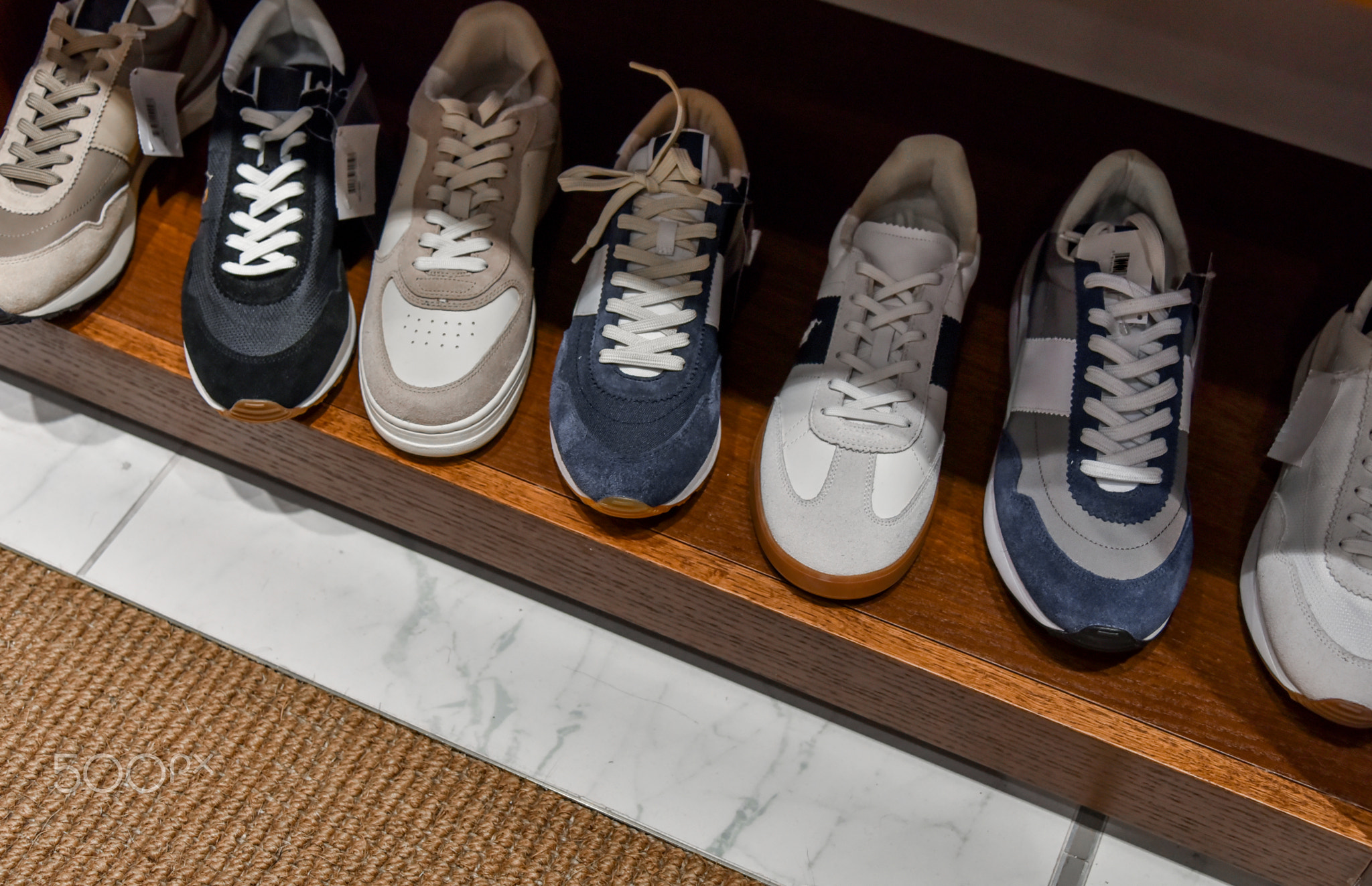 Men's retro vintage and casual sneakers sport shoes displayed on shelf in a row in fashion store.