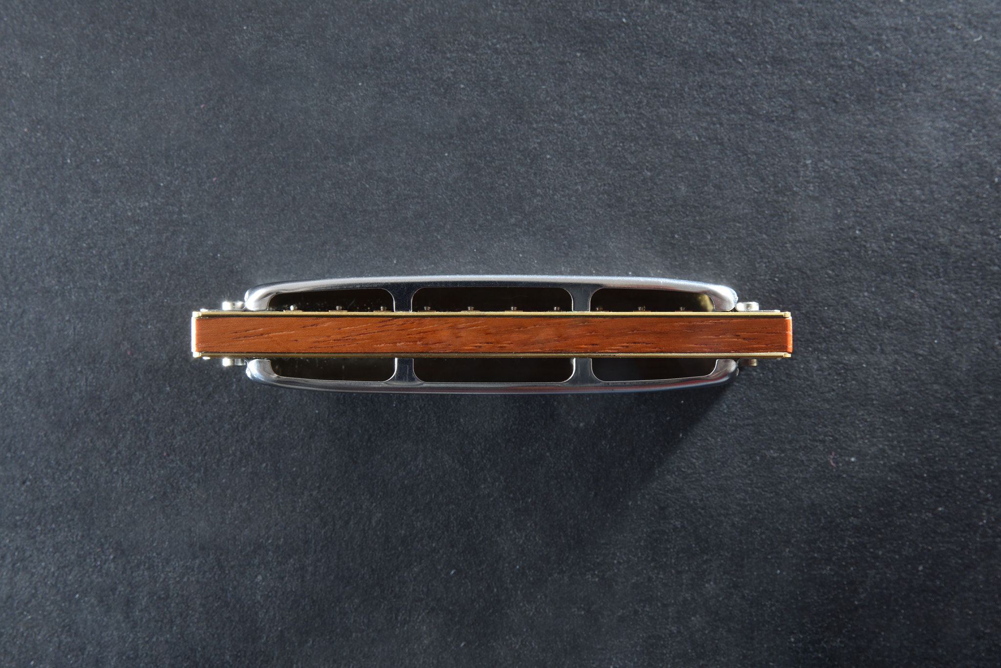 Back of metal and wood diatonic harmonica isolated black