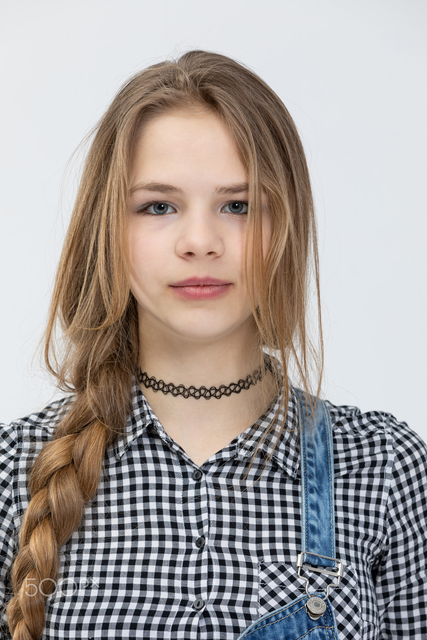 bust of a girl standing in front combed in braids