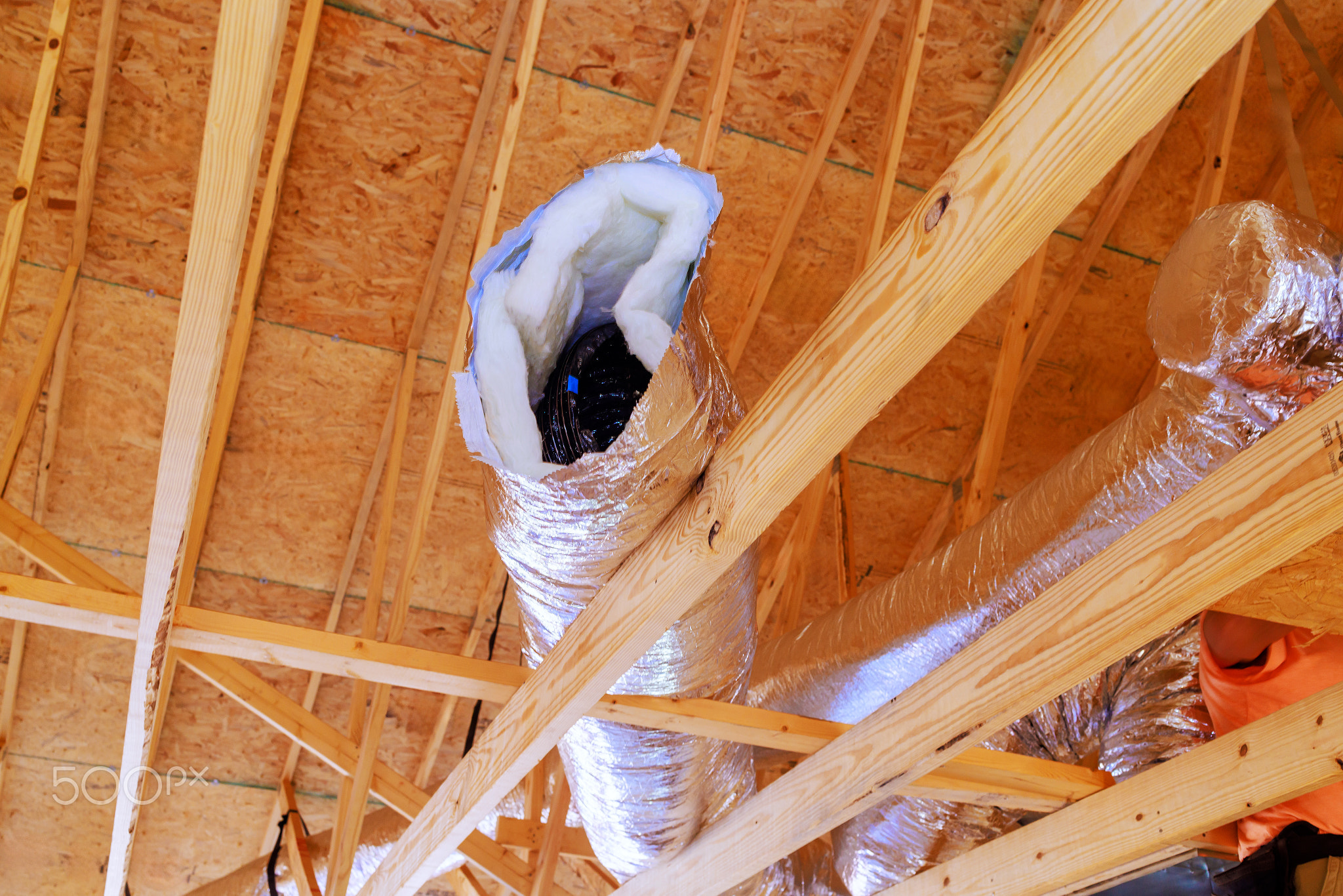 In construction of home, silver insulation ventilation HVAC pipes were