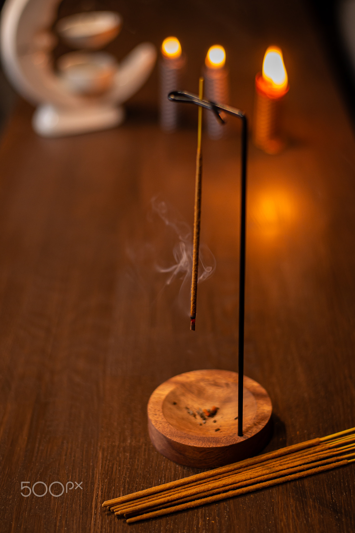 incense stick smokes on a wooden stand on a dark background. Aromatherapy, Smoke while burning