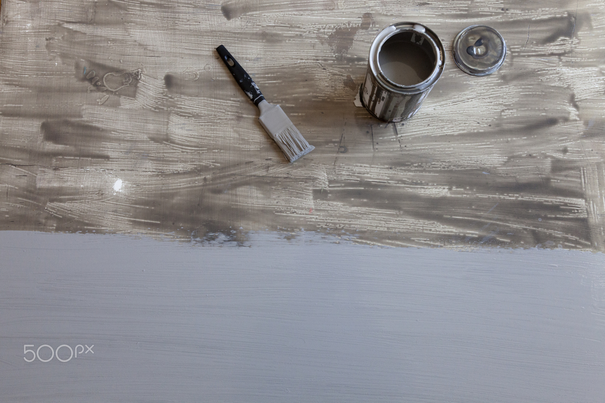 Top view of half painted wooden table with brush and opened paint on it. Flat lay