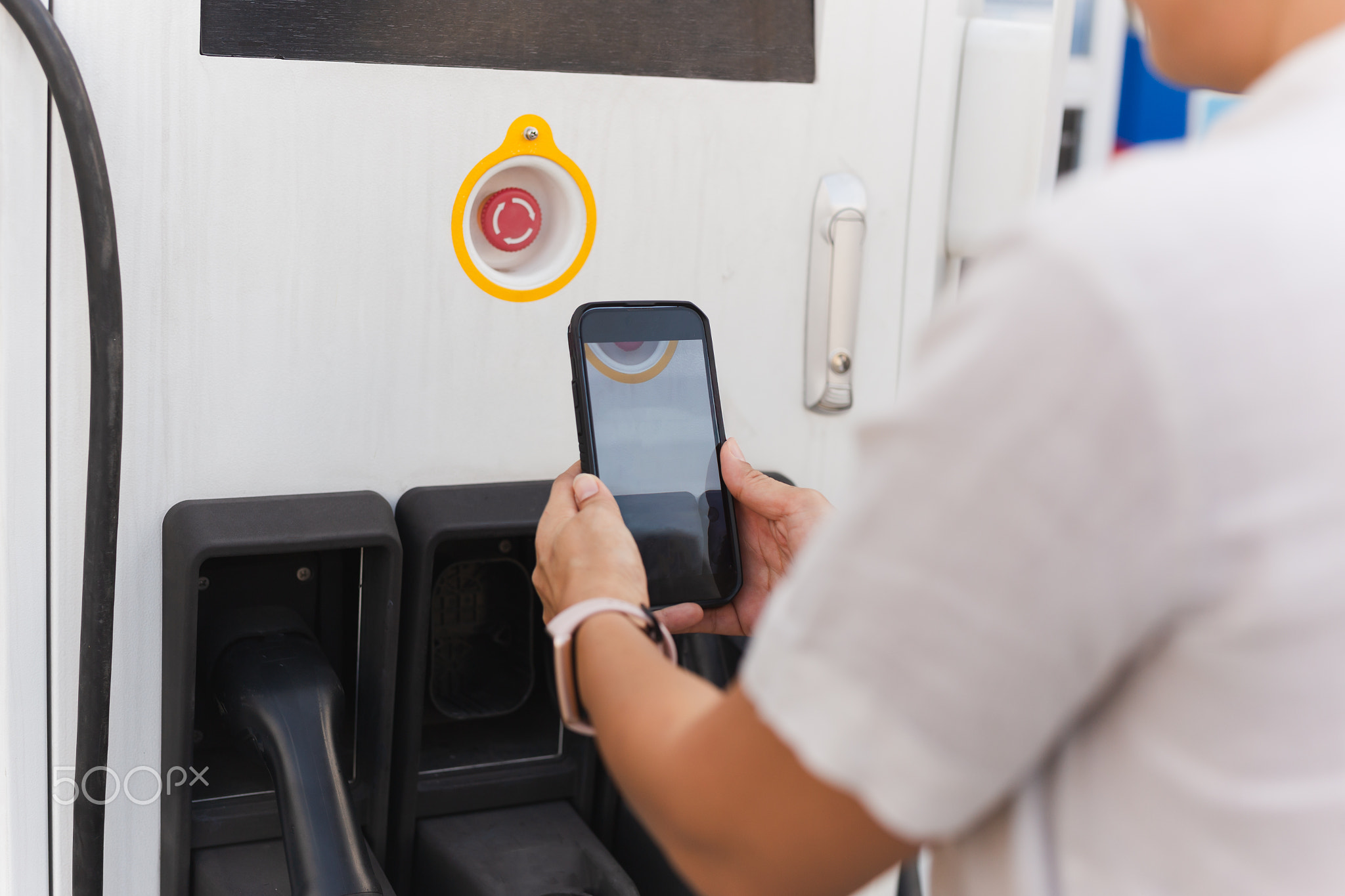 Woman going to charge electric car on vehicle public power station