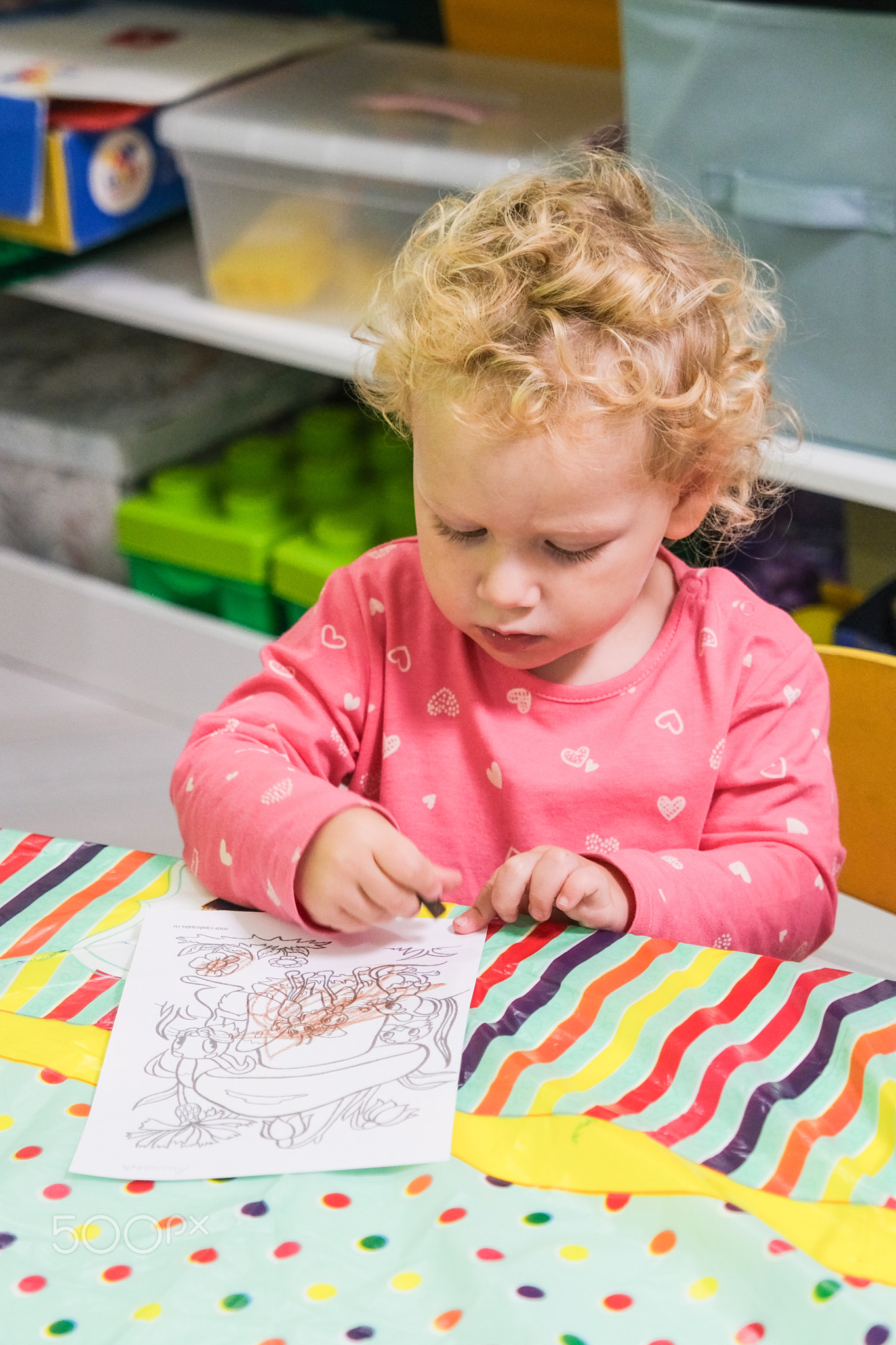 Beautiful blonde baby girl playing in kindergarten