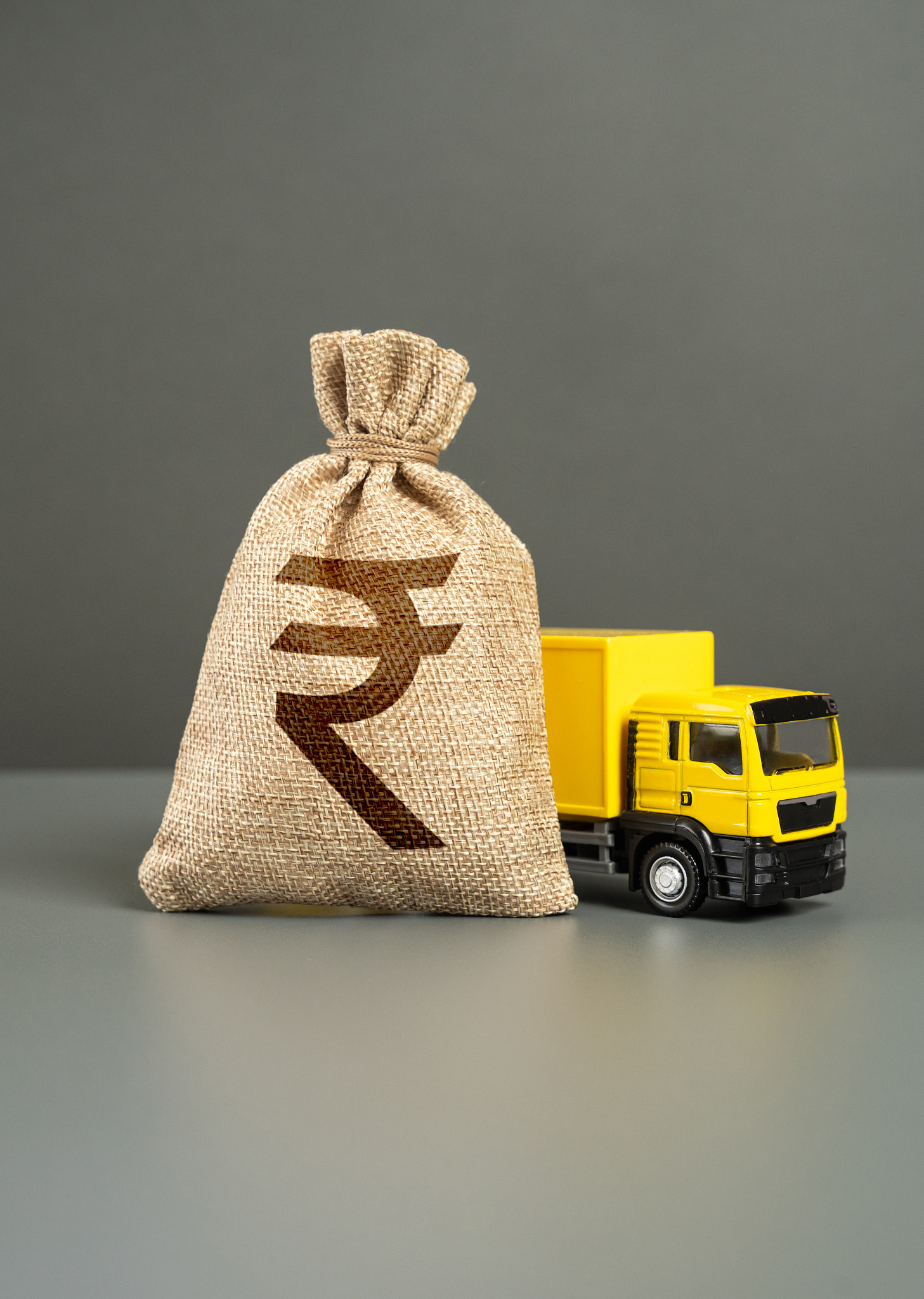 Delivery truck and Indian rupee money bag. Profit and taxes from cargo transportation. Growth in fre