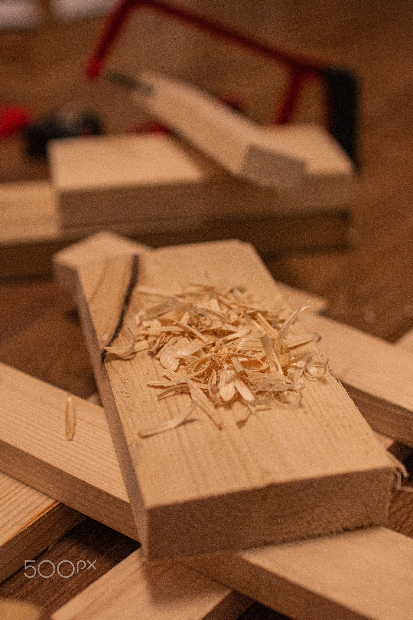 A pile of wood shavings rests on a wooden plank