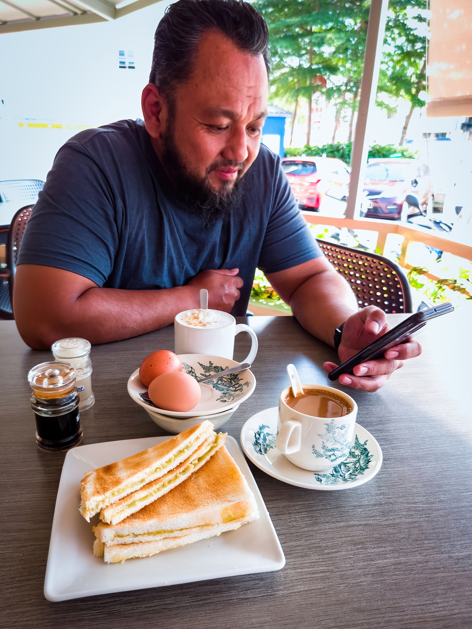Asian traditional breakfast combination of half boiled eggs, toast bread with butter and kaya and co