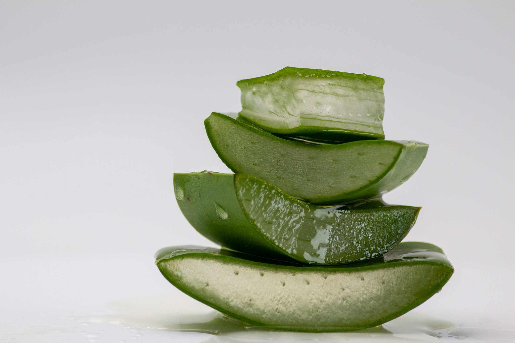 Macro shot of sliced and stacked aloe vera isolated on white background.