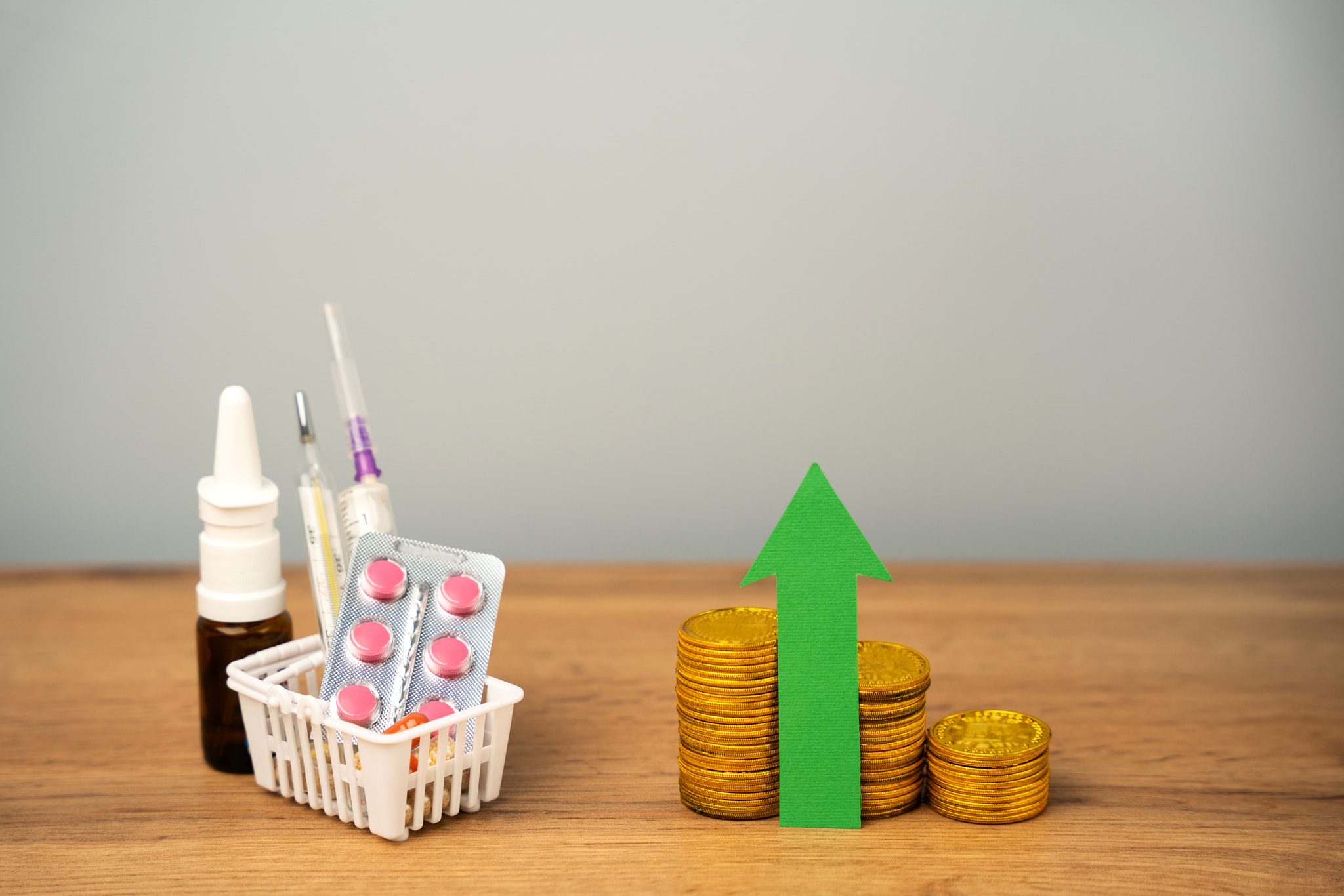 Up arrow, coins and basket with medical pills. Concept of growth the price of medicines and drugs. H