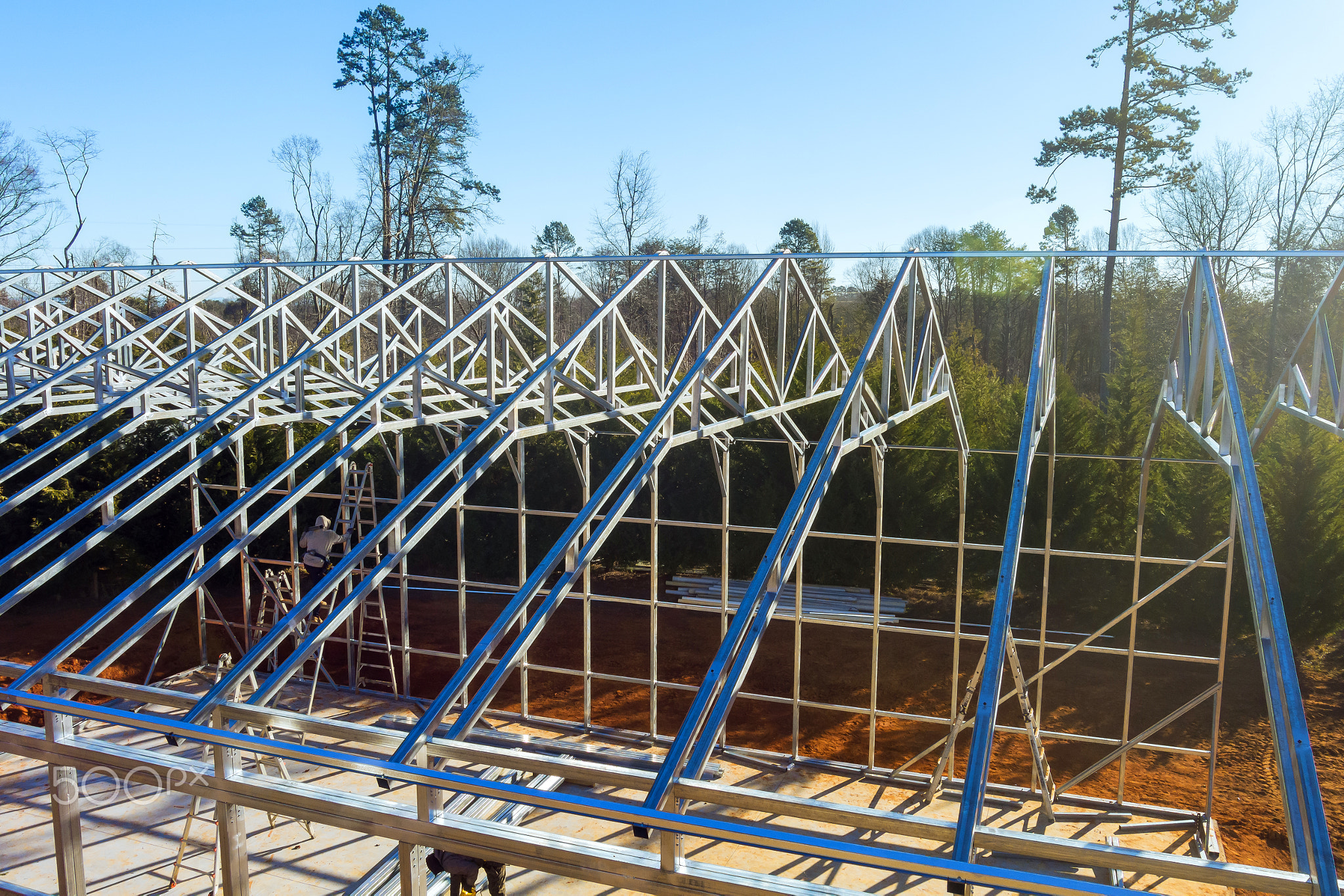 Construction of a modern steel framed building in a forested area