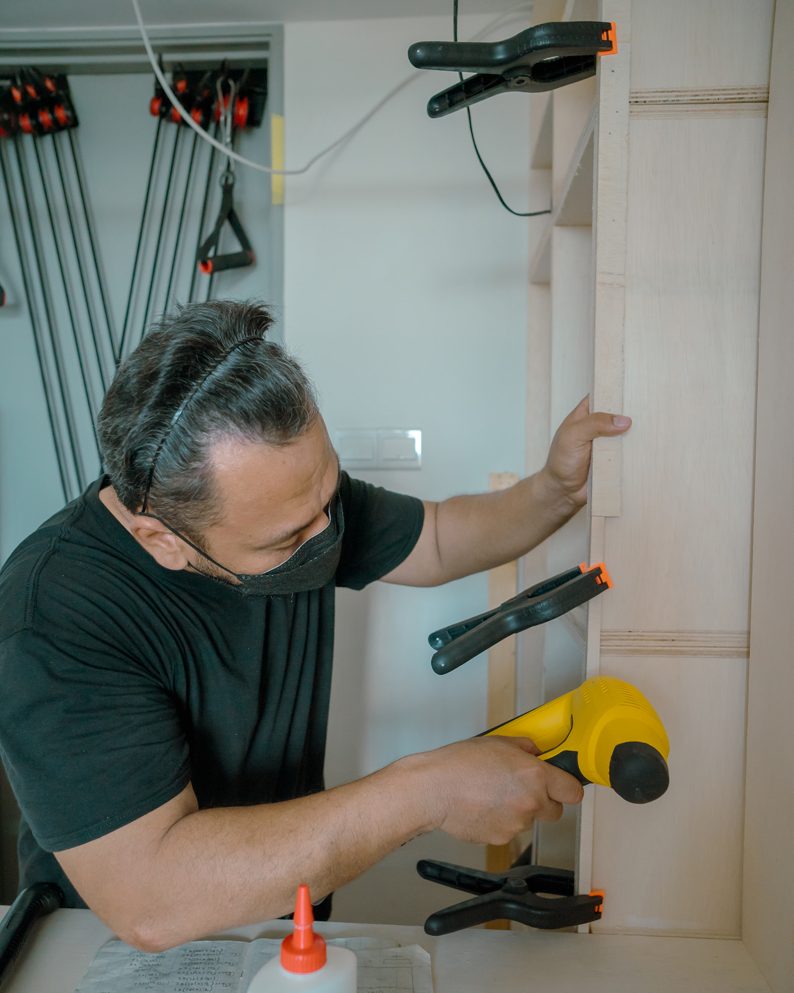 Man using Framing Nailer to attach wooden plywoods.