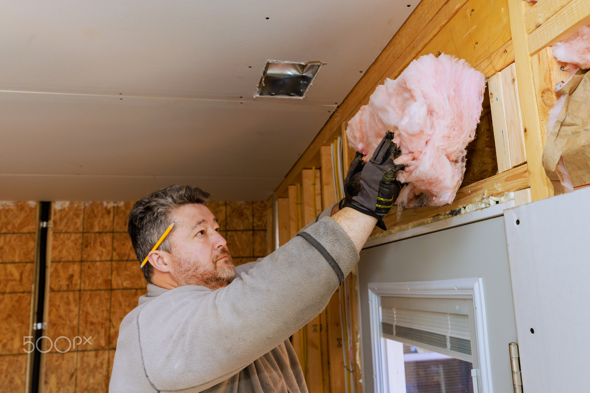 Construction worker installing insulation in a residential building