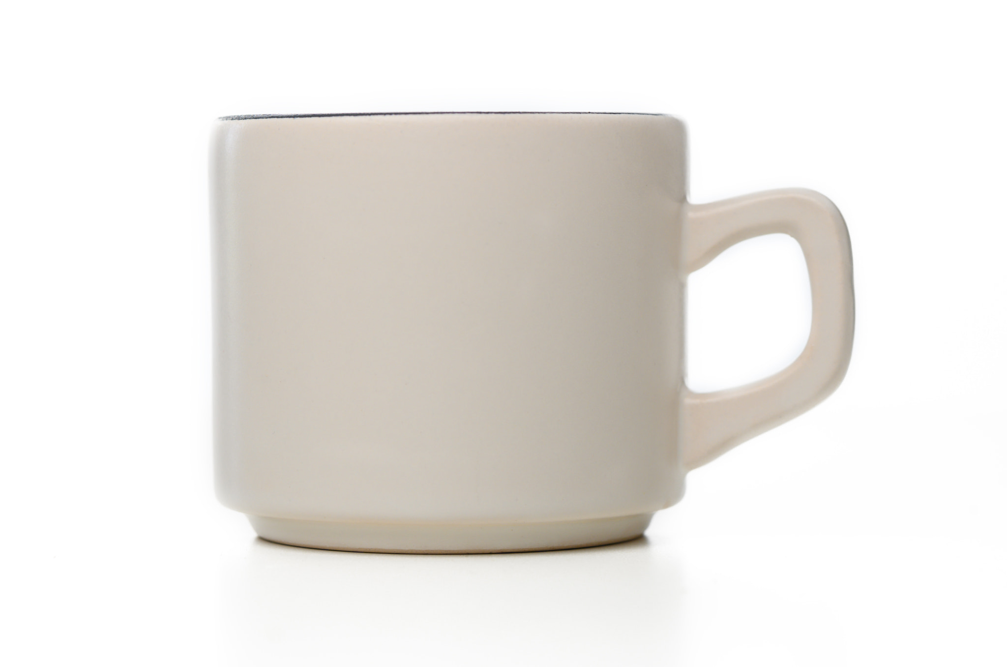 Simple yet elegant ceramic mug in soft cream color placed against a minimalistic background setting
