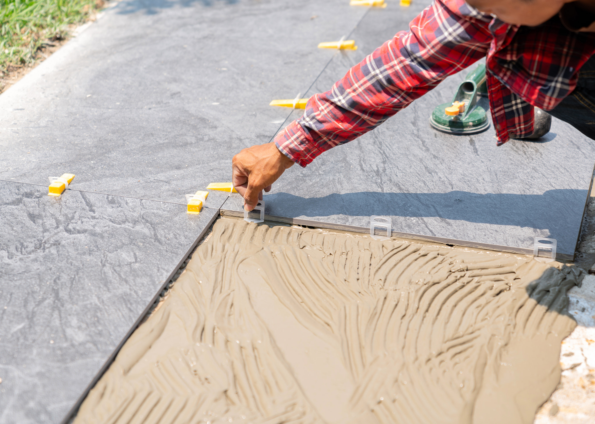 Worker use Plastic clip-on tile leveling on floor.