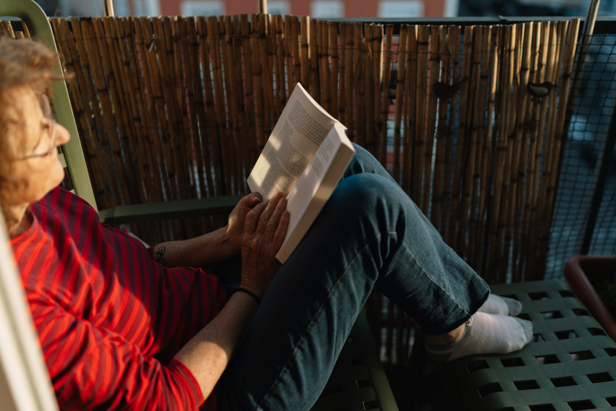 Woman reading newspaper while sitting on chair