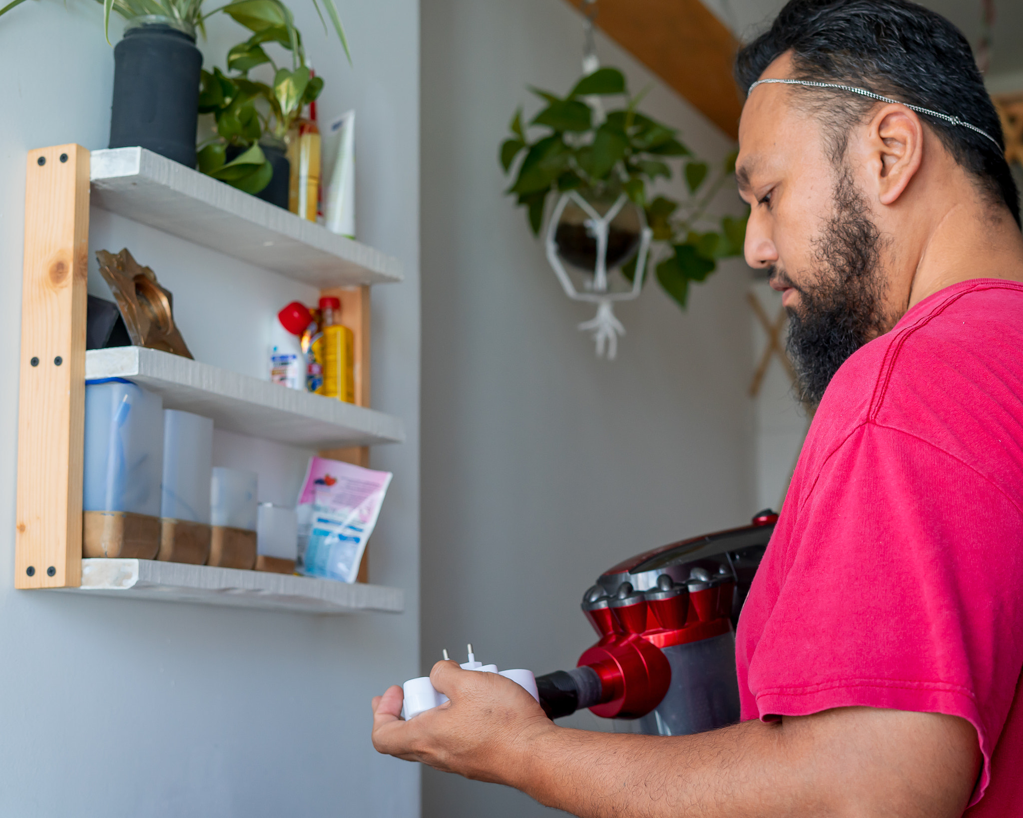 Asian bearded matured man is cleaning the house with vacuum cleaner.: Asian bearded matured man is cleaning the house with vacuum cleaner.