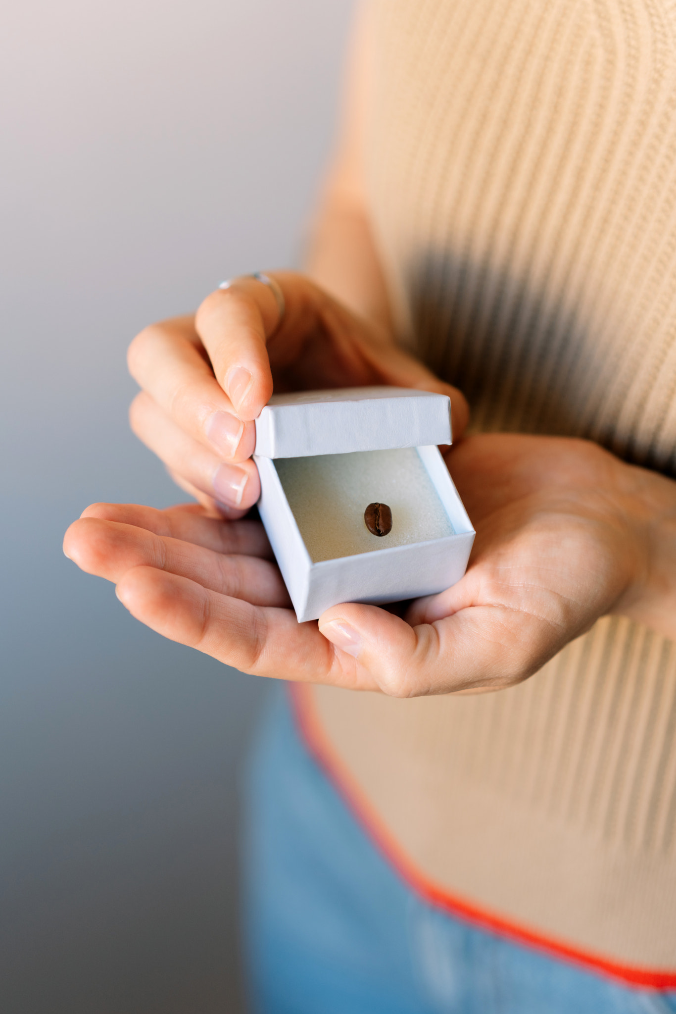 Midsection of woman holding box with a coffee bean