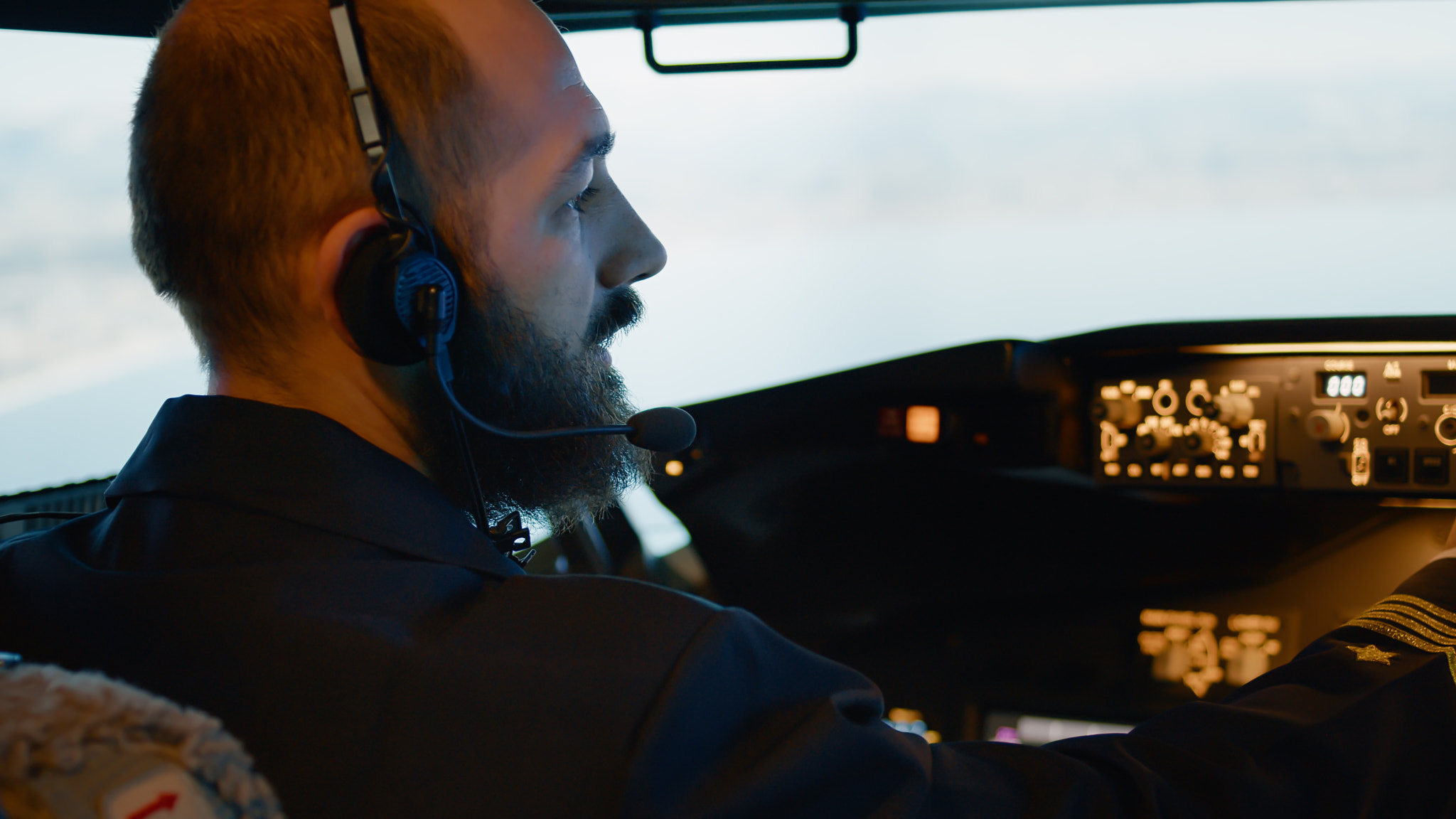 Male captain piloting airplane with engine throttle and power switch