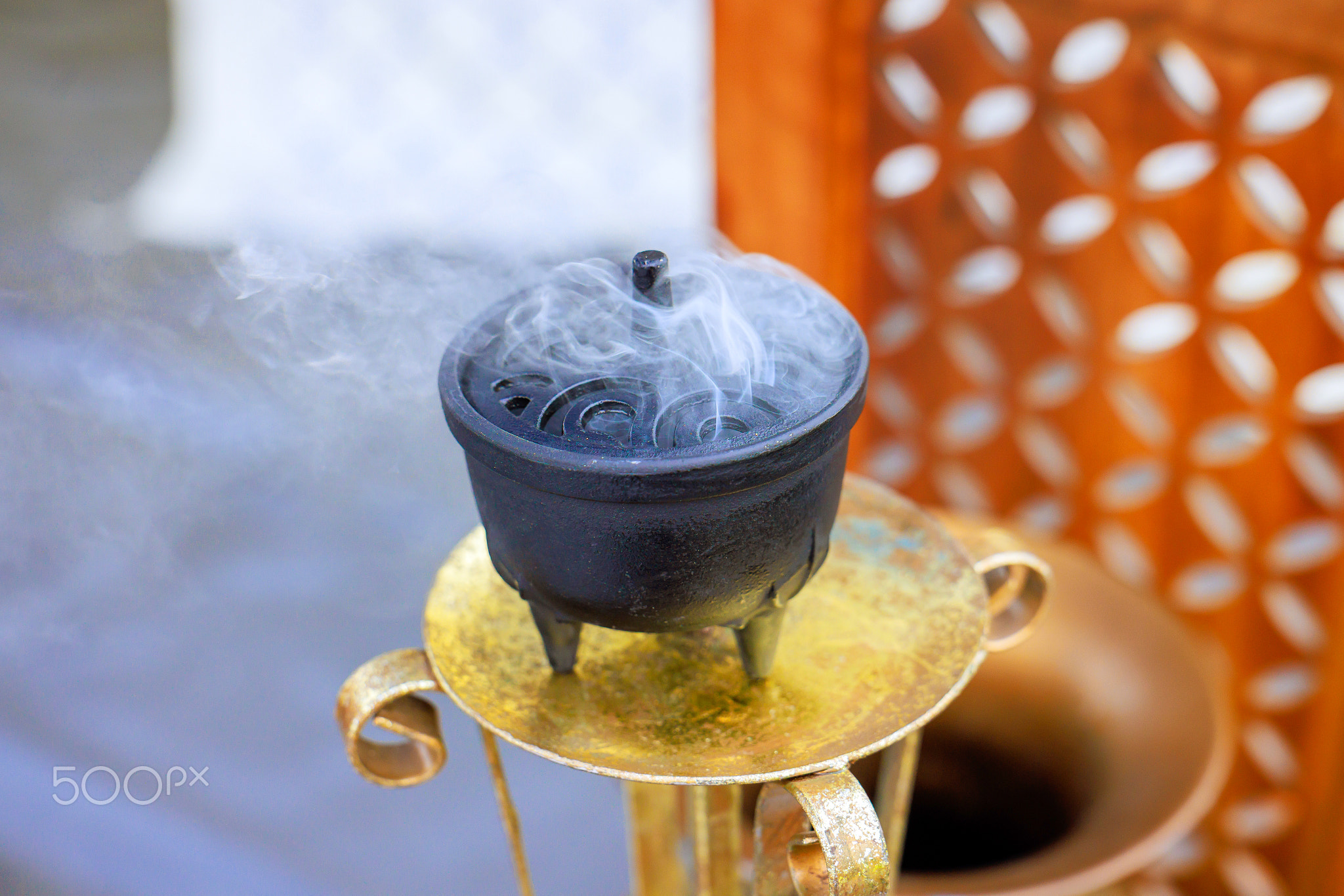 Incense burner releases fragrant smoke during tranquil outdoor