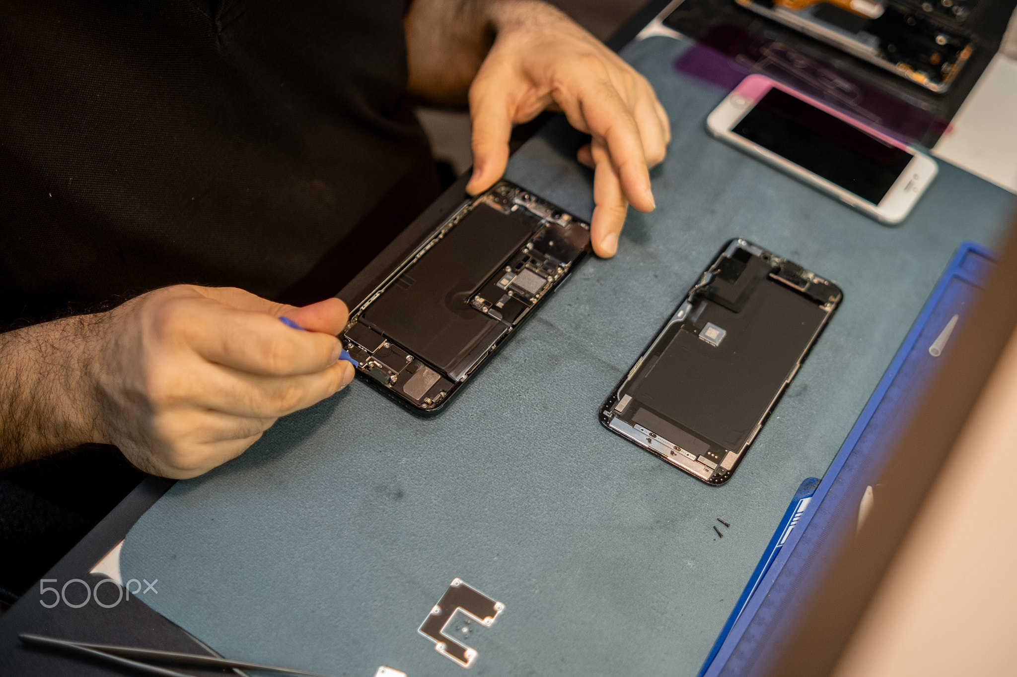 Expert Phone Technician Repairs Smartphone Components in a Dedicated Workspace, Showcasing Precision