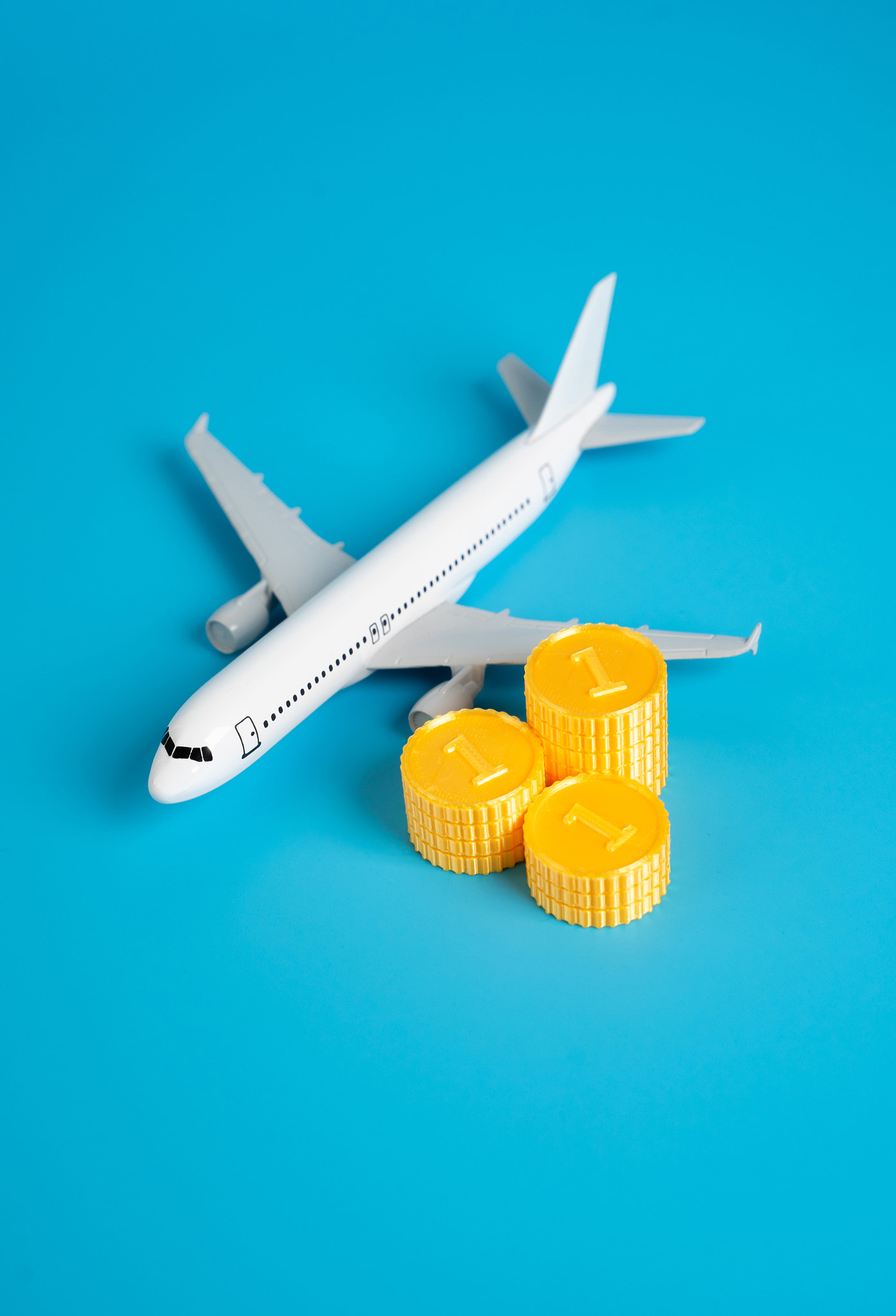 Airplane and a stack of coins. Flights and air traffic. Income and taxes. Saving on bonus programs.