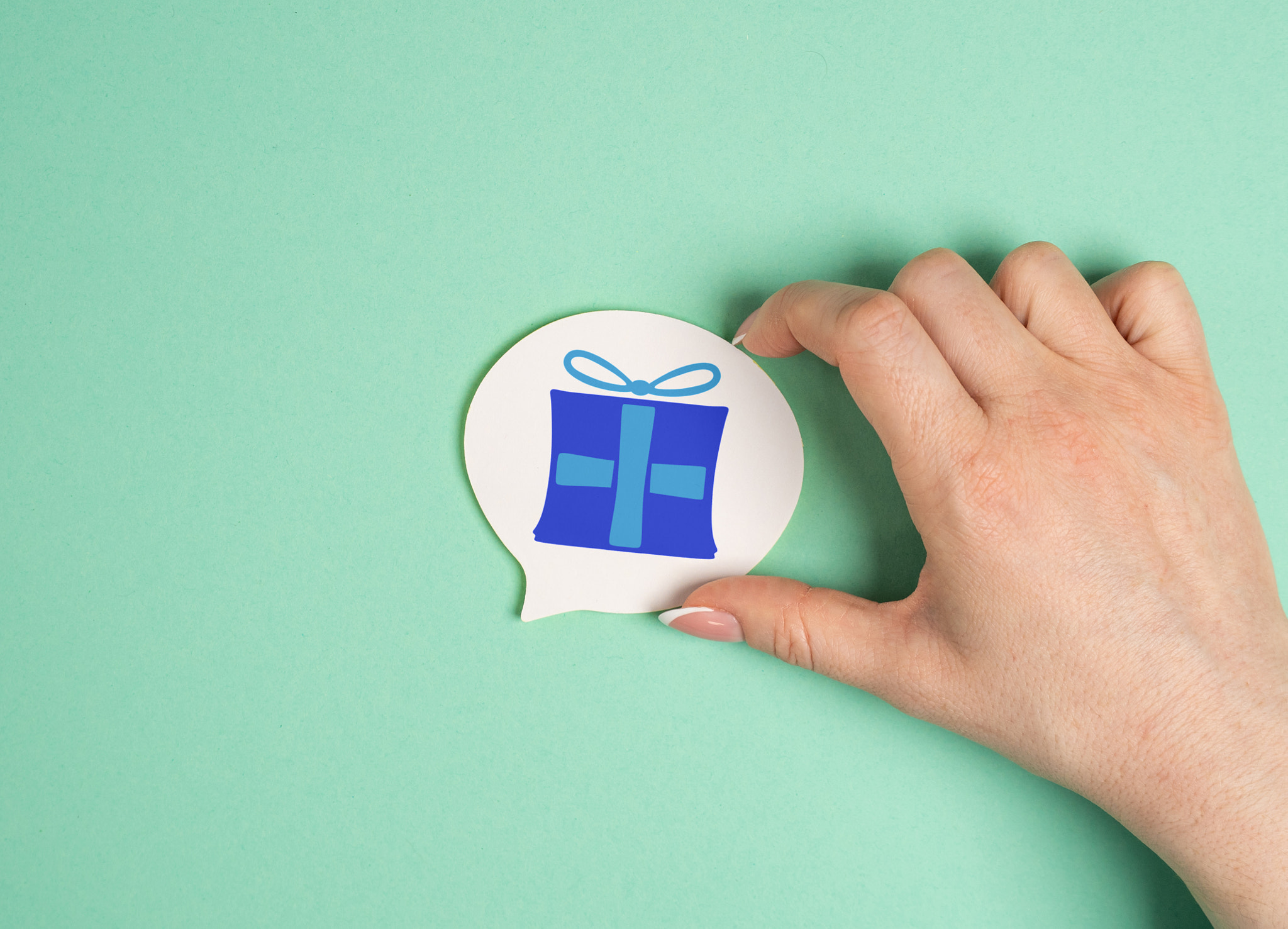 Hand holds sticker with gift picture. Receive prize, win award. Promotional incentives on a sale.