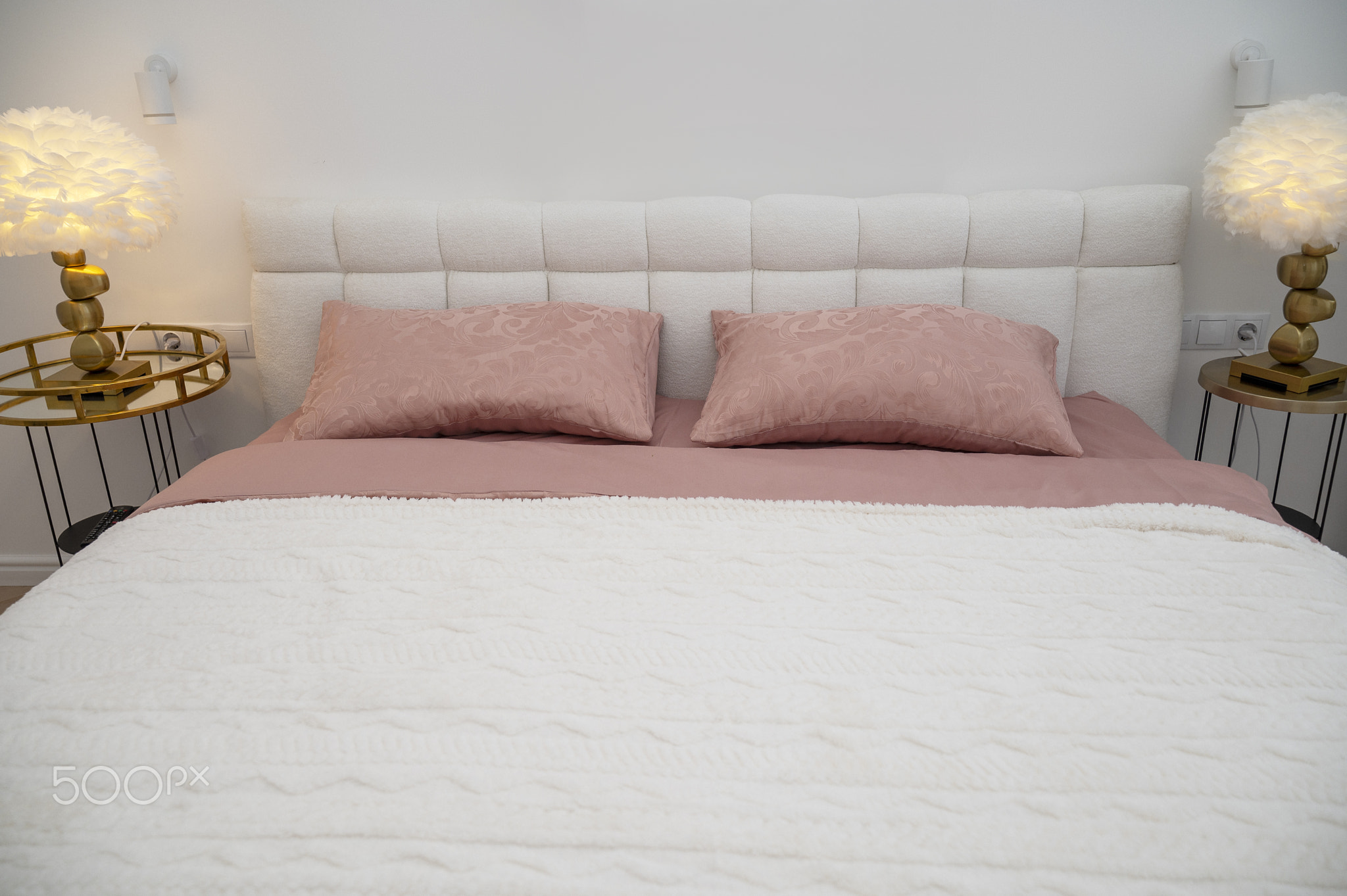 double bed with white headboard and dark pink bed linen and white blanket