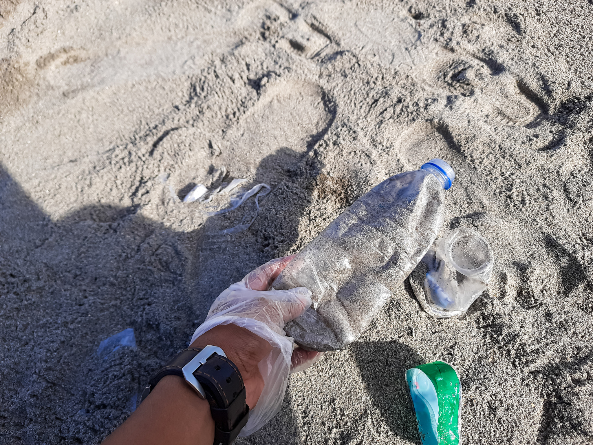 Man Picking Up Plastic Bottle Waste on Beach in Pariaman, Indonesia