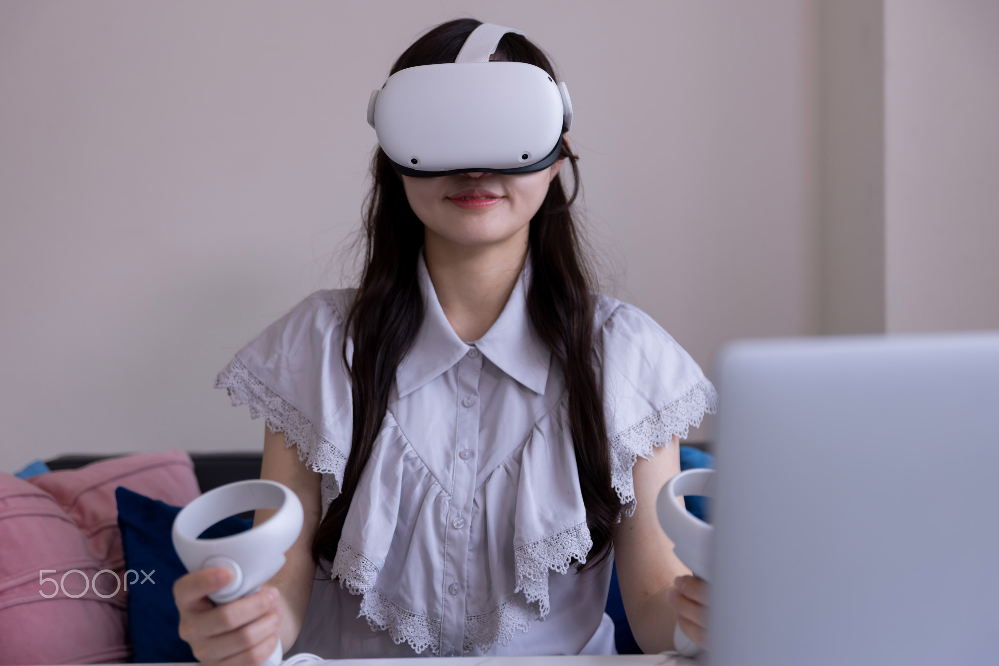 A Japanese woman wearing VR glass in front of PC and tablet in the room