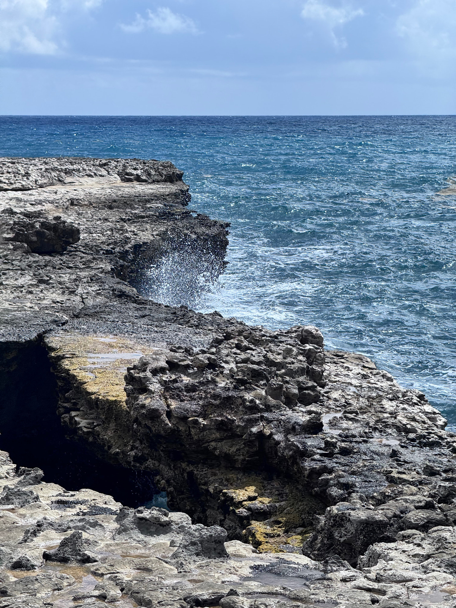 Scenic view of sea splashing against the terrain of Devils Bridge