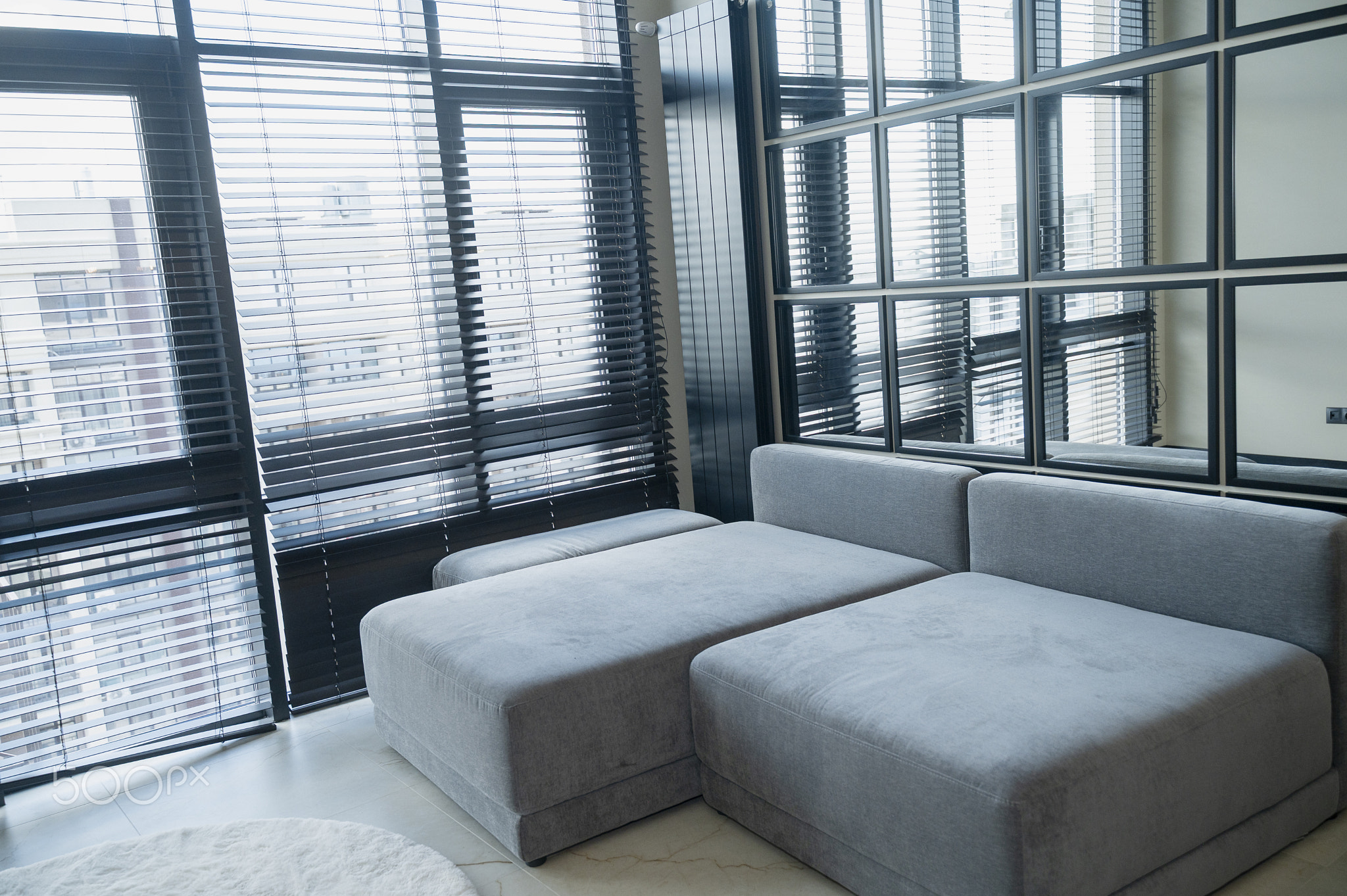 Gray, modern, Ergonomic sofa standing near a large window with blinds