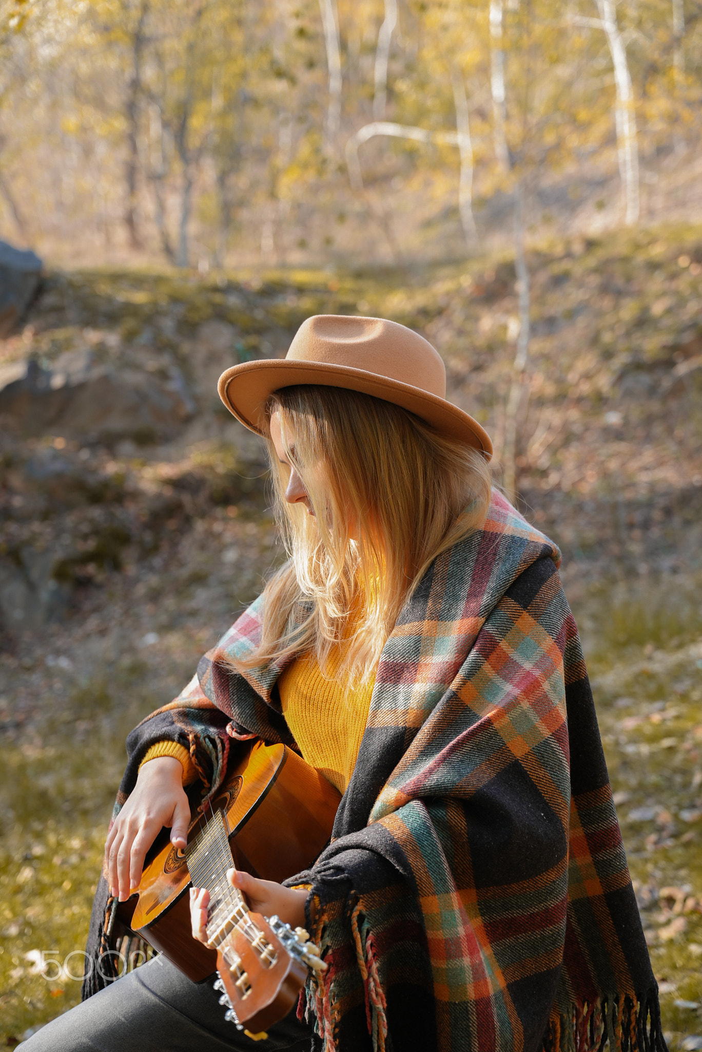 Portrait of smiling caucasian artist plays wooden acoustic guitar in
