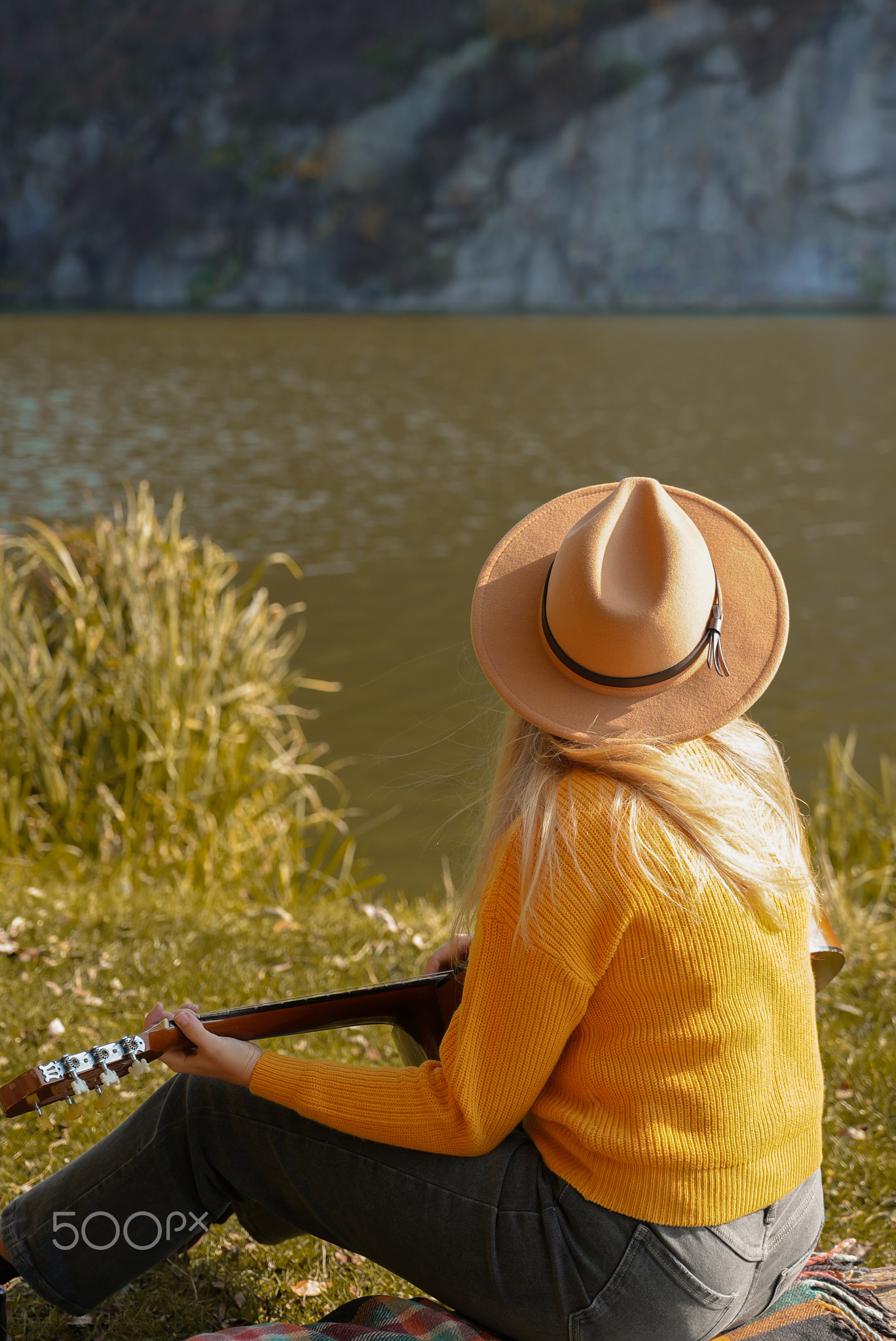 Portrait of smiling caucasian artist plays wooden acoustic guitar in