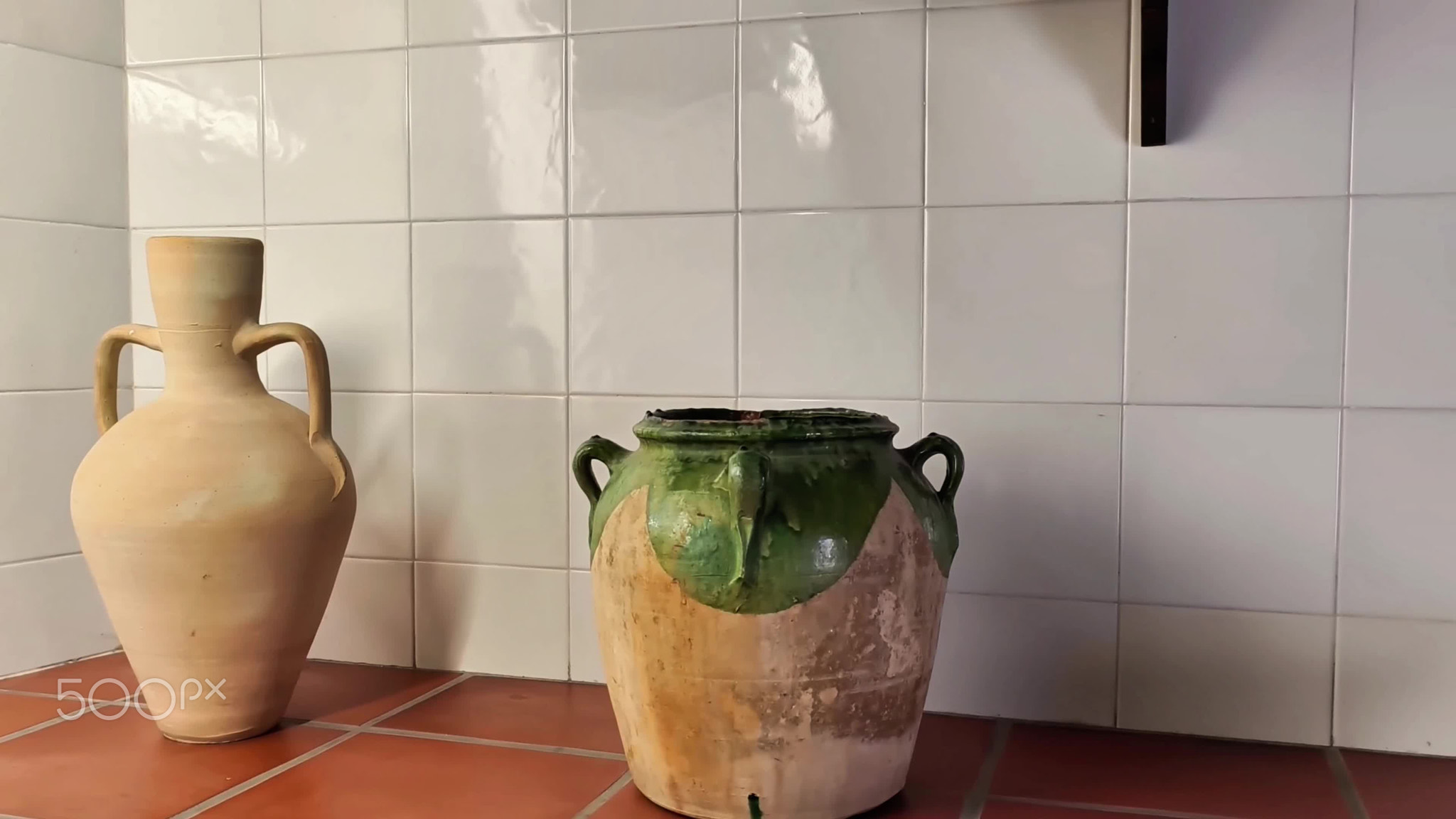 Beautifully Crafted Rustic Ceramic Pots Arranged on a Tile Countertop in a Cozy Kitchen