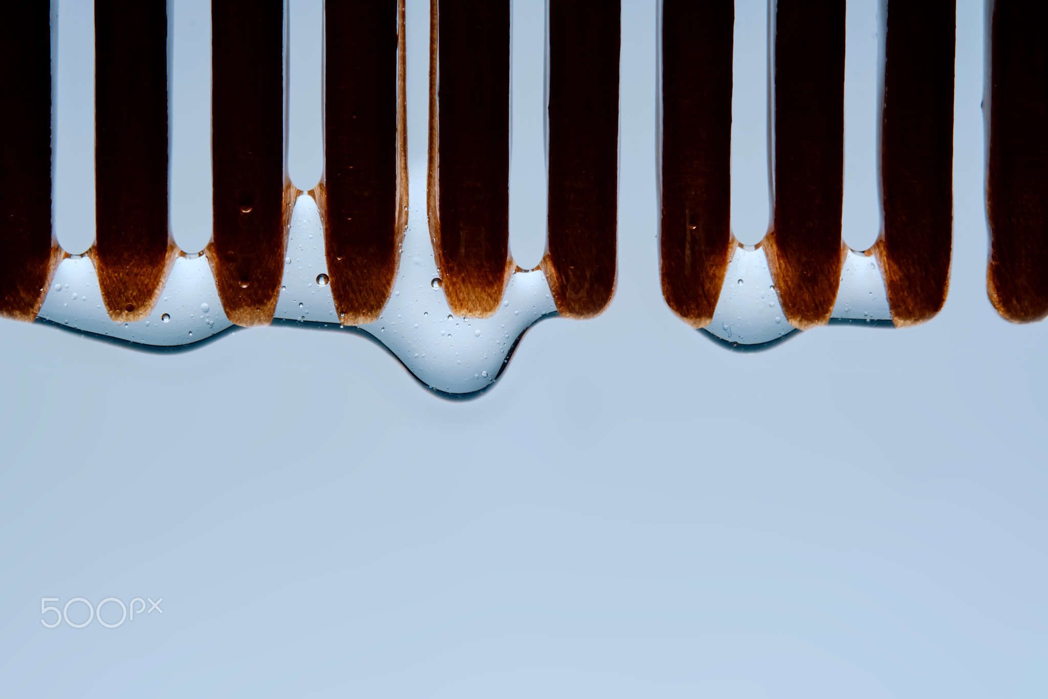 A comb with hair serum. The photo shows the texture of the cosmetic product.