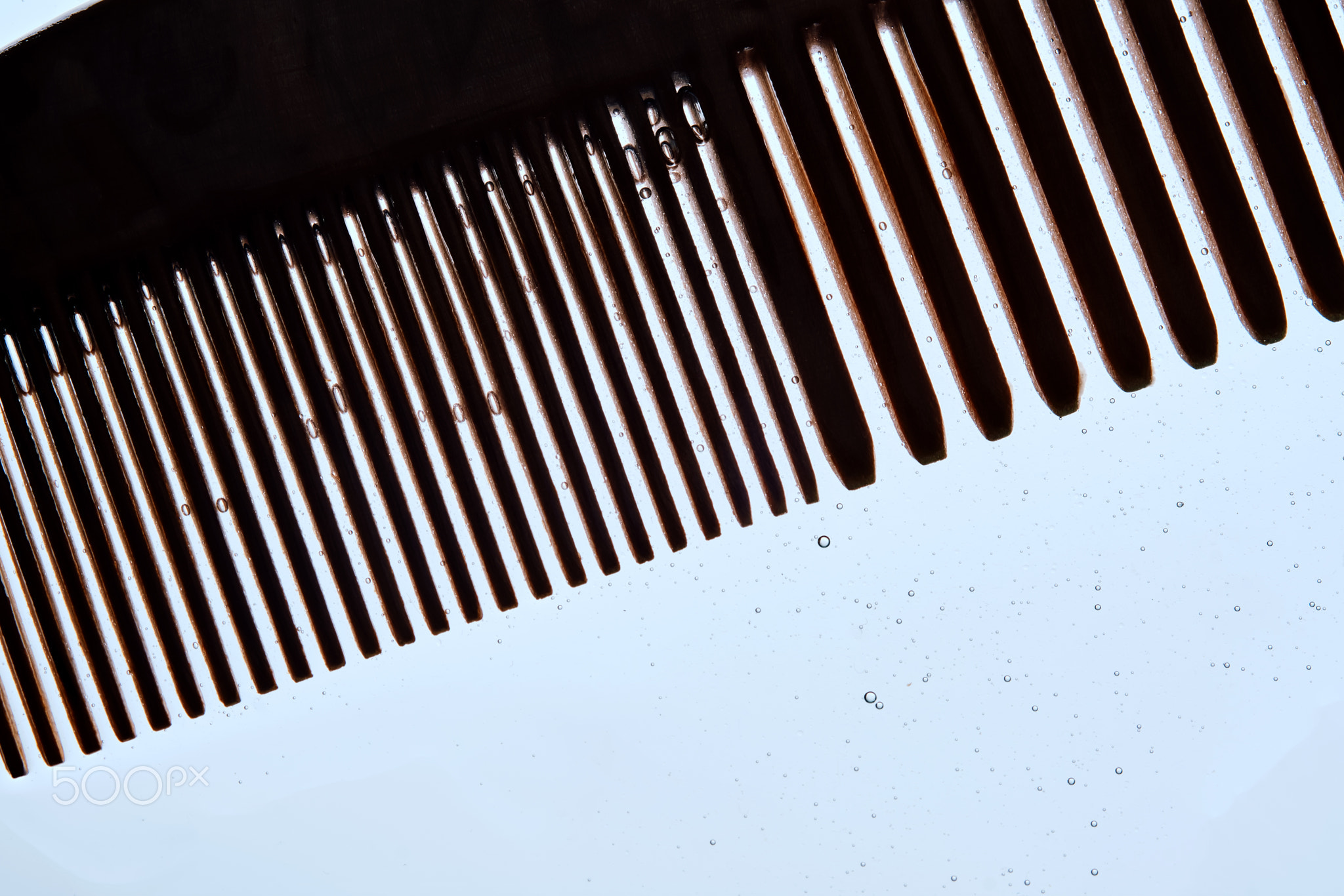 A comb with hair serum. The photo shows the texture of the cosmetic product.
