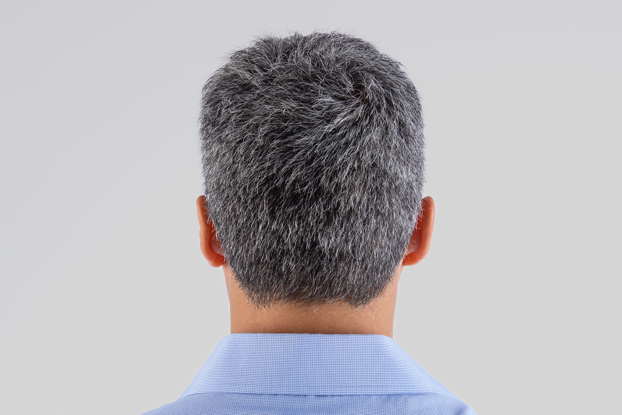 A man with a gray head and a blue shirt