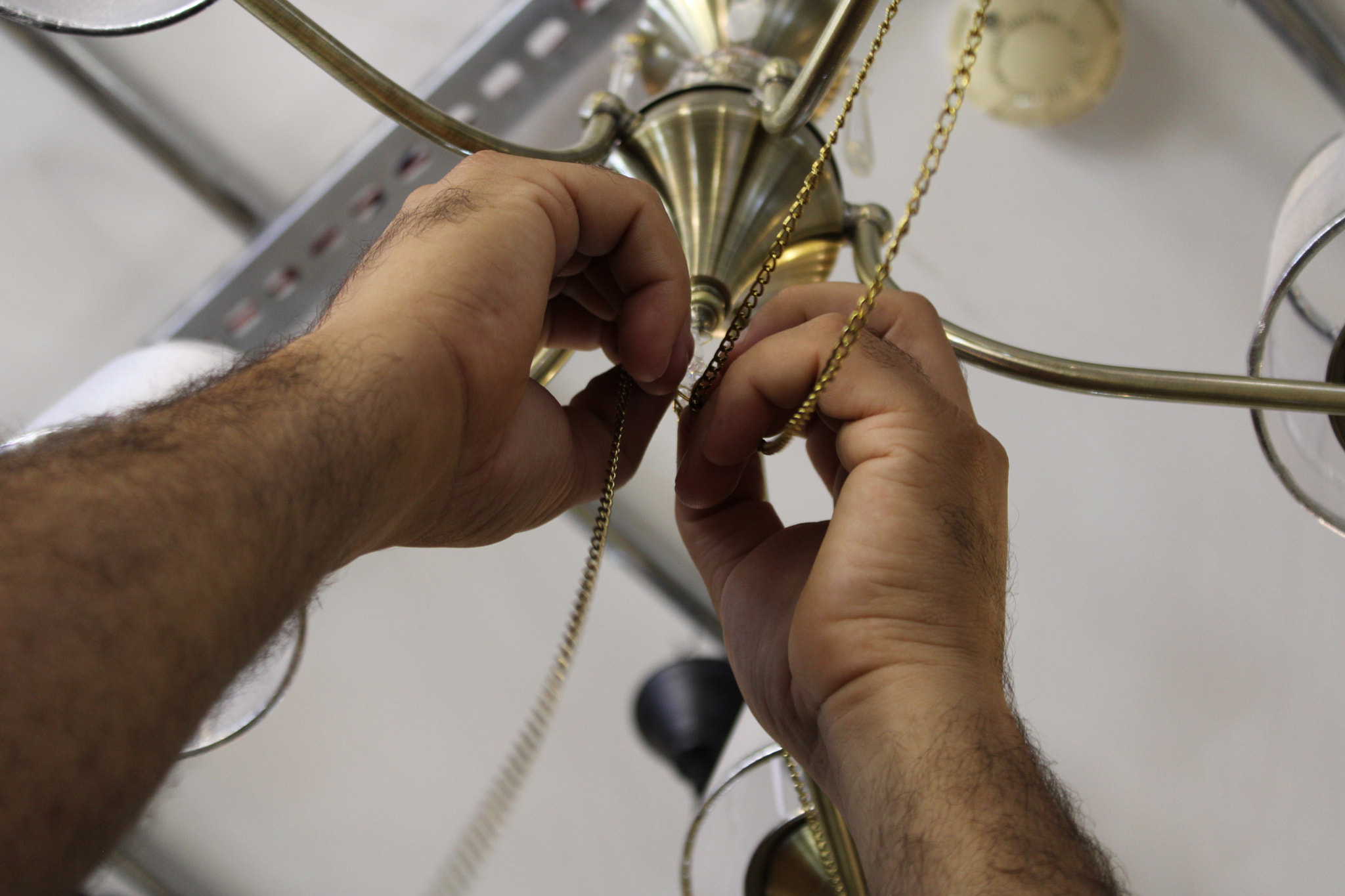 Cropped hands of man repairing eyeglasses