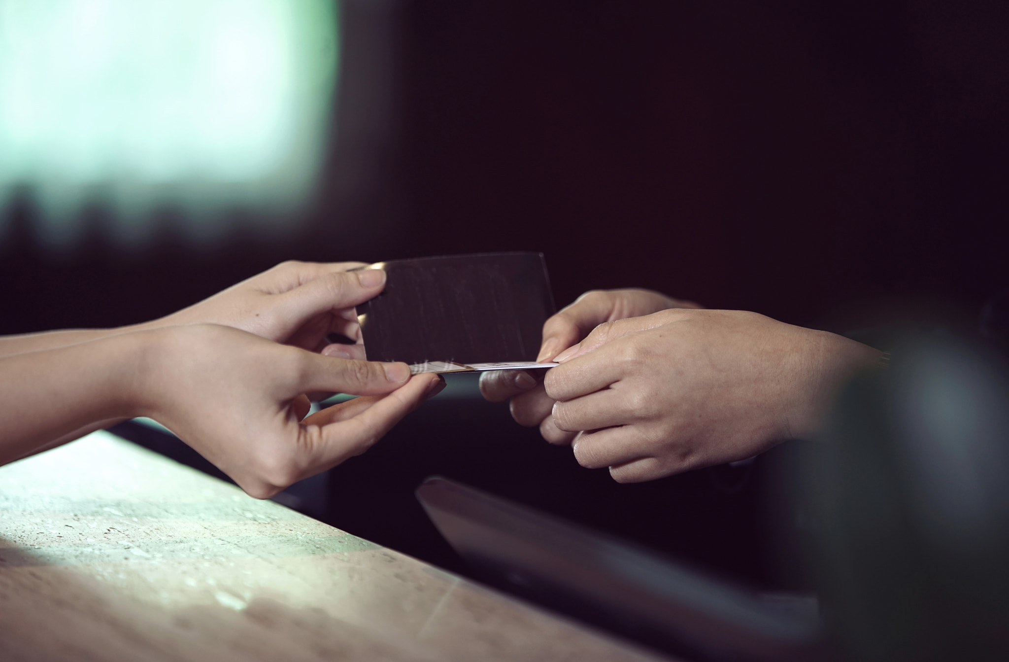 Two hands exchange a business card and transactions, highlighting networking, professional contact, 