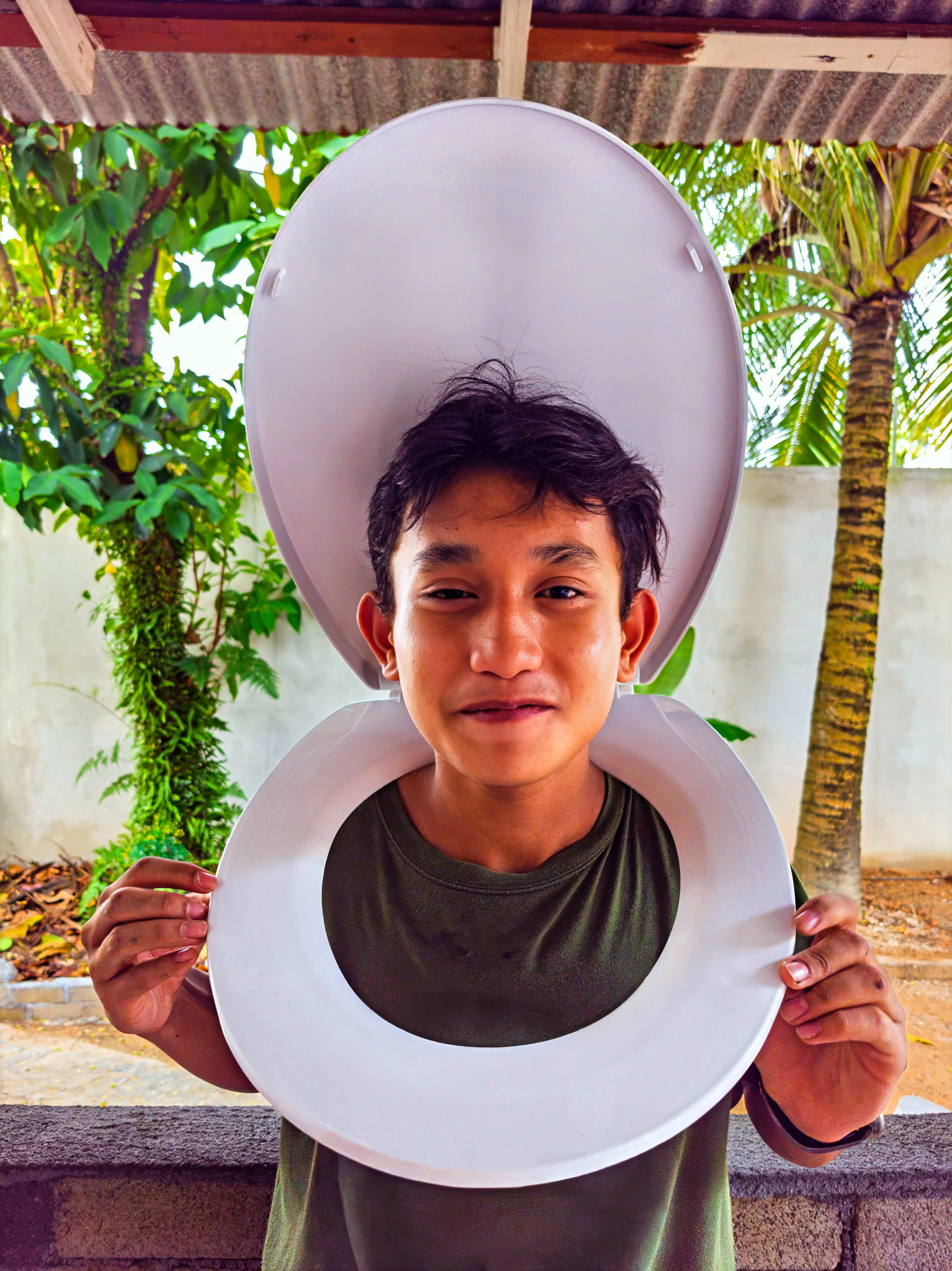 Smirking boy wearing toilet seat on his body.  Cosplay and halloween concept.