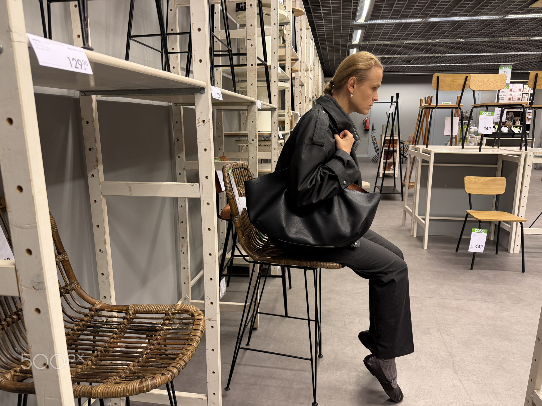 Woman sitting on stool in furniture store