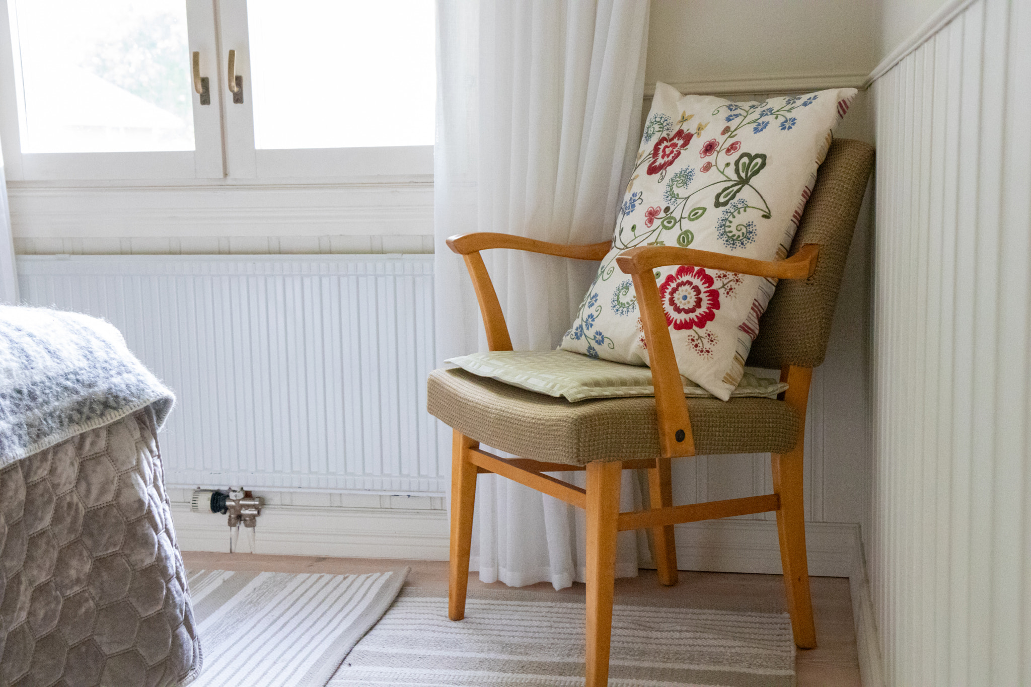 Mid-century modern Scandinavian armchair with wooden frame and curved design, featuring a floral emb