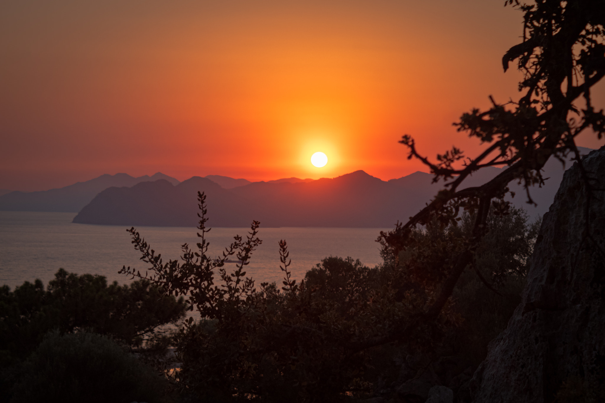 Panoramic view of a golden sunset over mountain ridges and Mediterranean sea waters